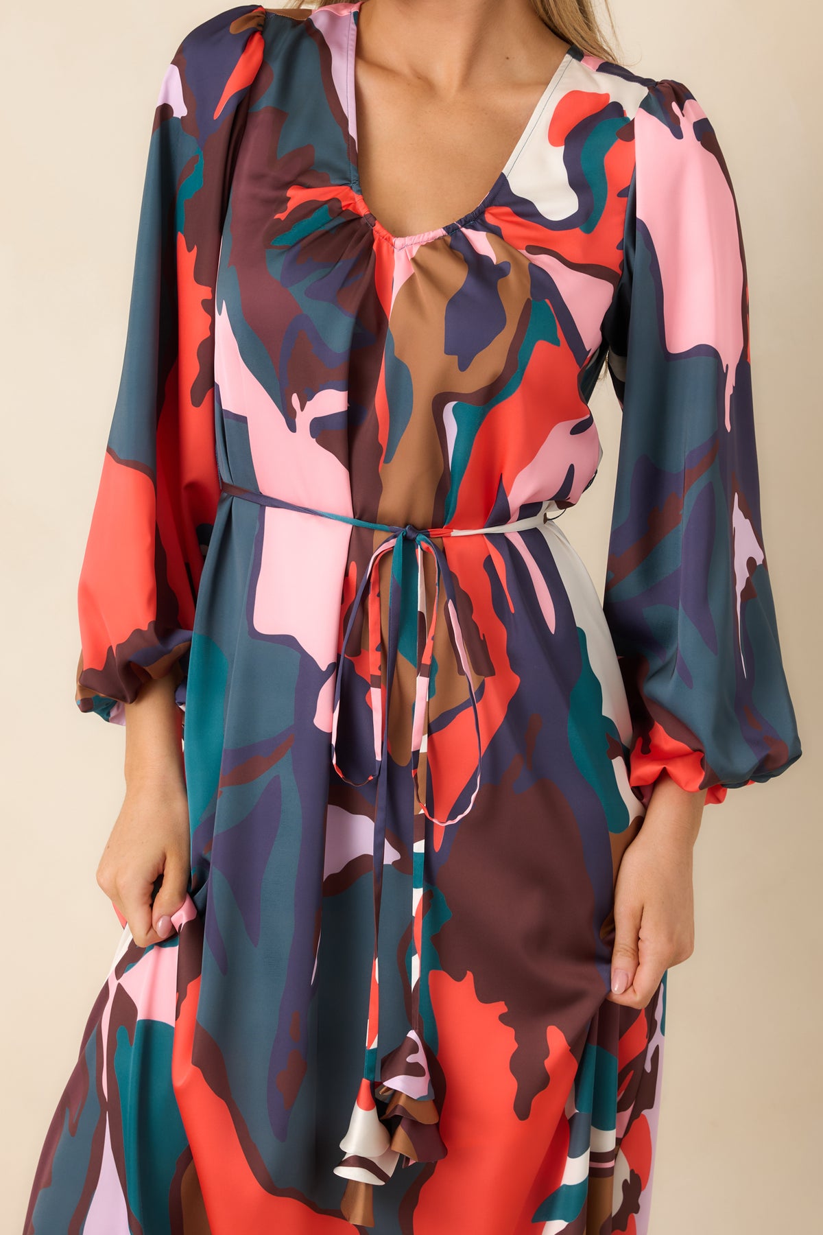 Removable skinny tie belt with playful fabric tassels against the softly lustrous multicolor dress.