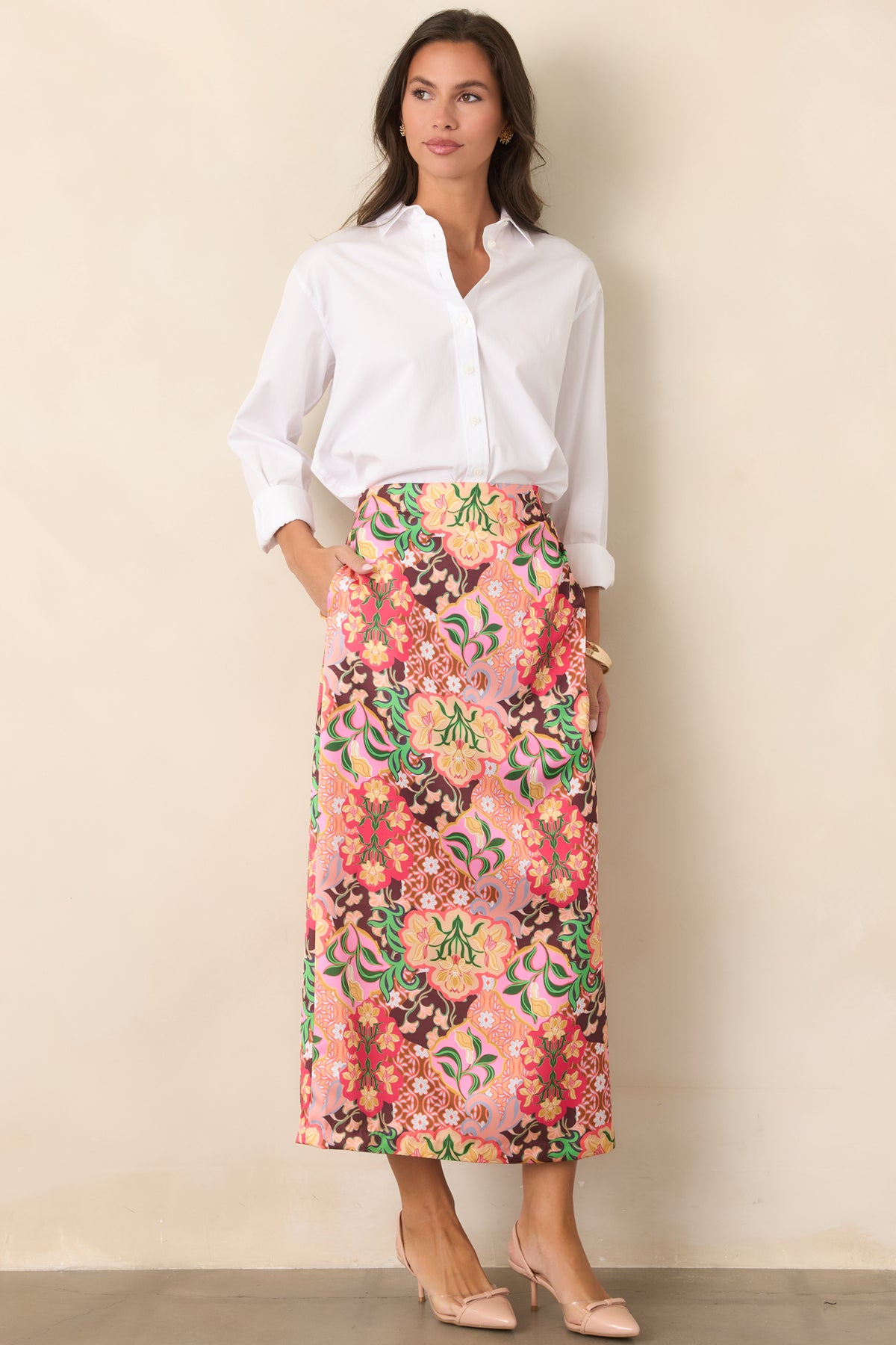 Midi skirt featuring retro floral medallions in pink, coral, yellow, green, and chocolate brown with a gently flared silhouette.

