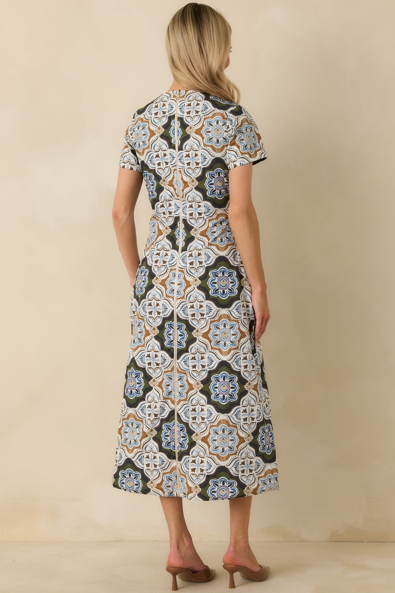 Rear view of the reversible dress featuring a full-length gold-tone zipper and intricate medallion print.