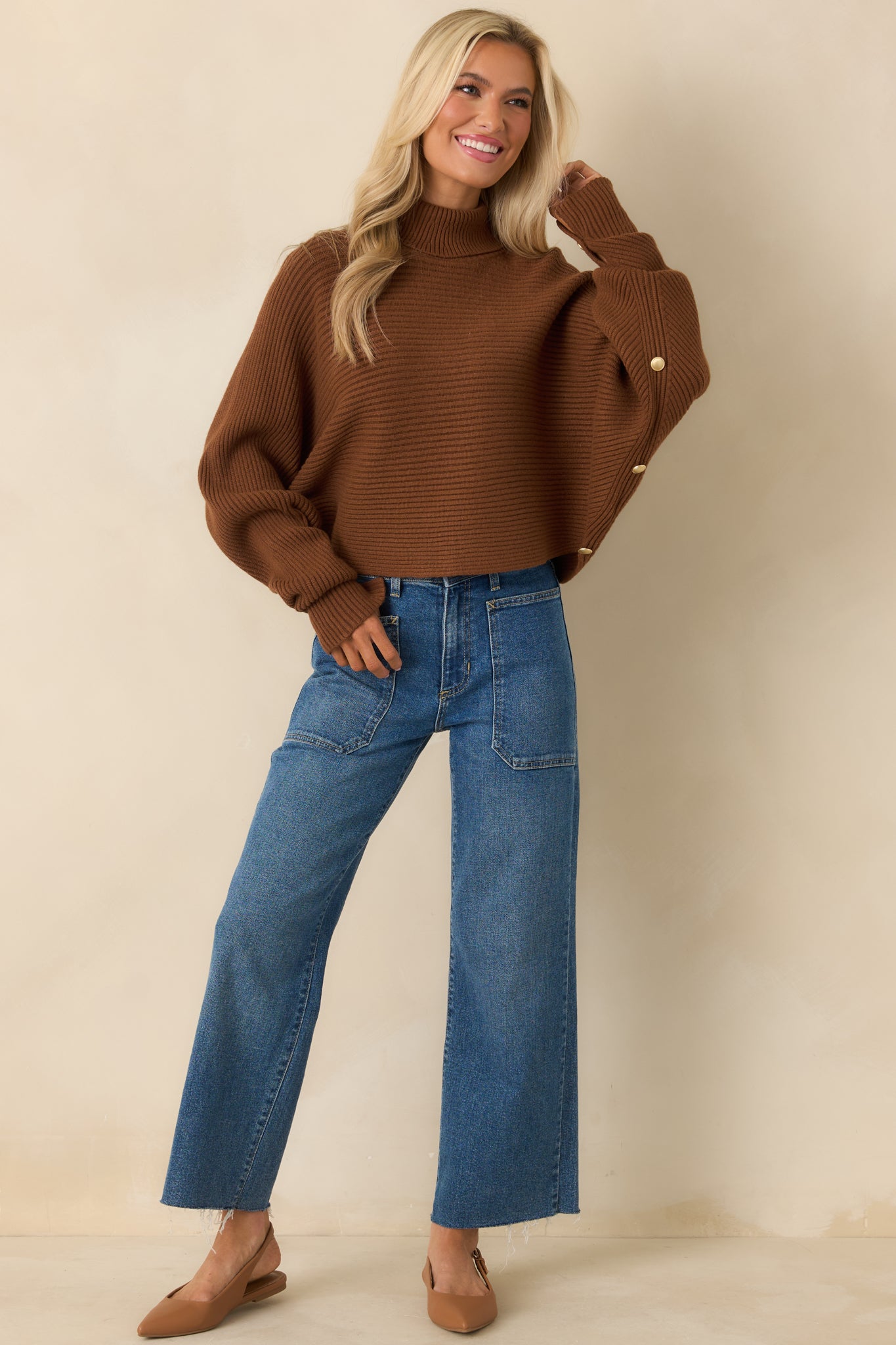 Ribbed brown sweater showcasing draped batwing sleeves and cropped hemline.