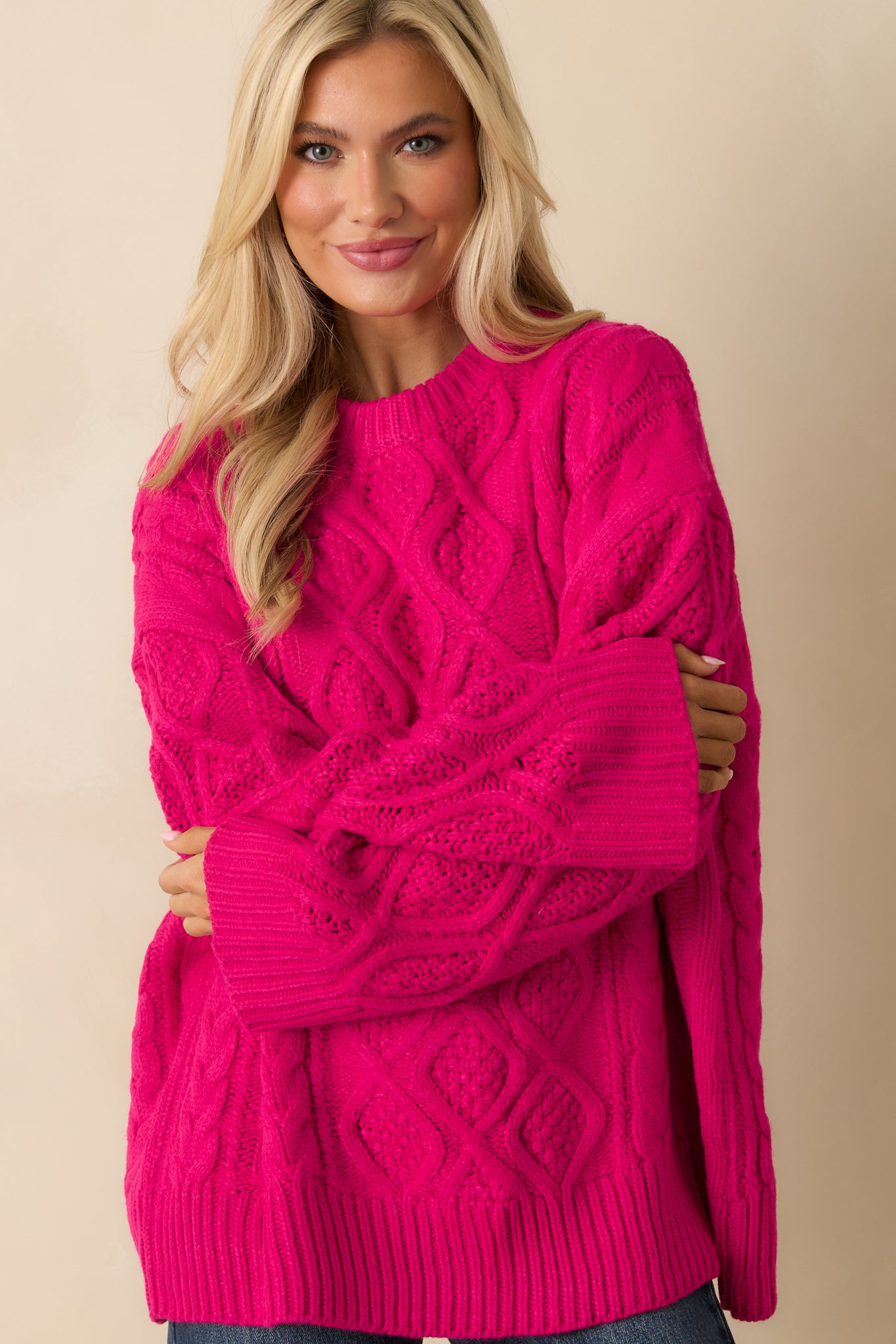 Focus on the ribbed cuffs and cable knit texture on the long sleeves.