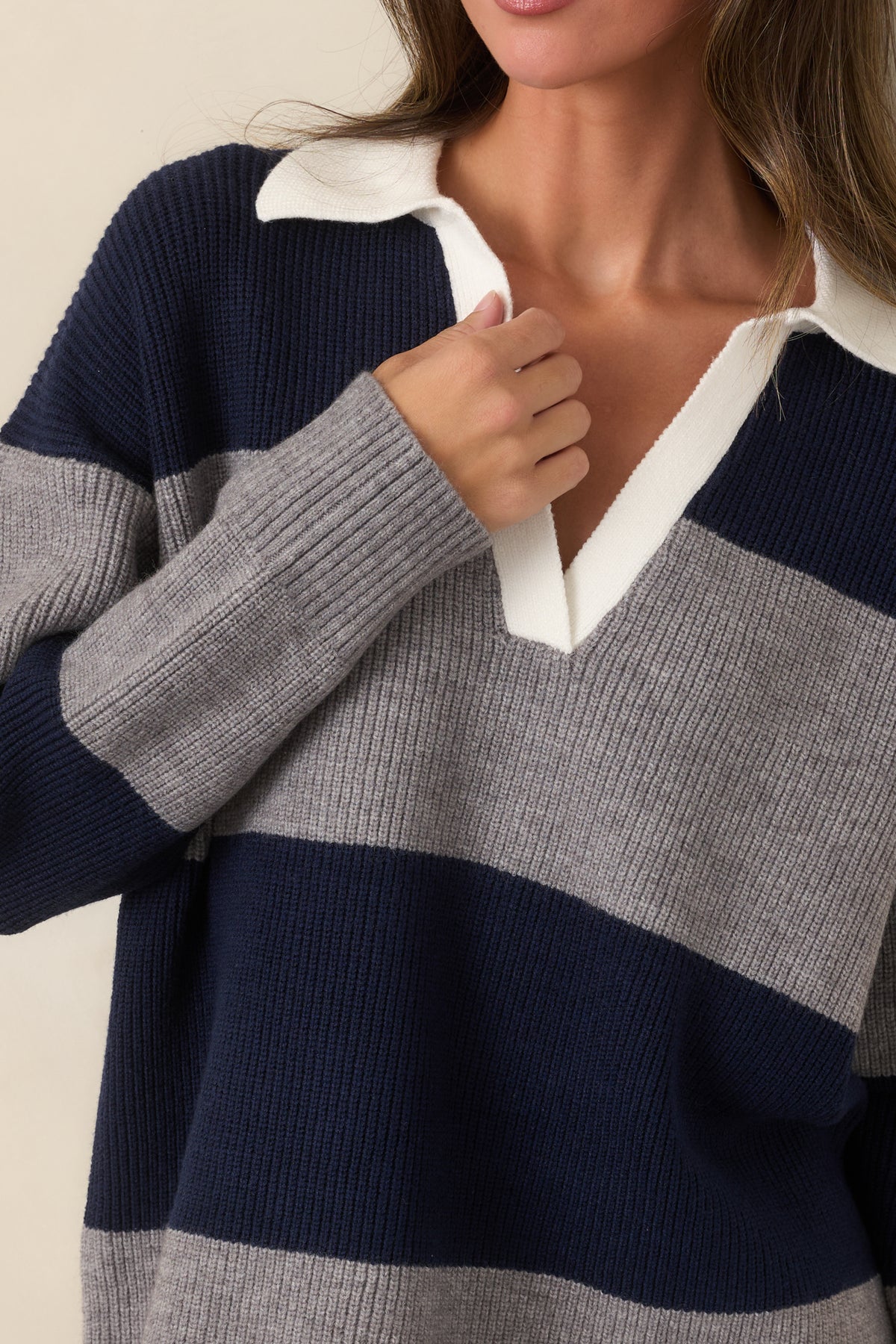Close-up of the ribbed knit showing the ivory collar and open V-neckline.