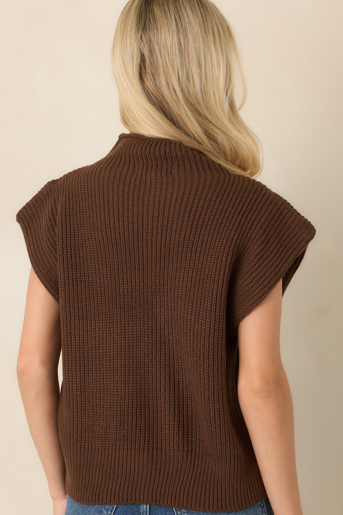 Rear of the cozy ribbed knit top showing the relaxed bodice, extended shoulders, and wide ribbed hem.