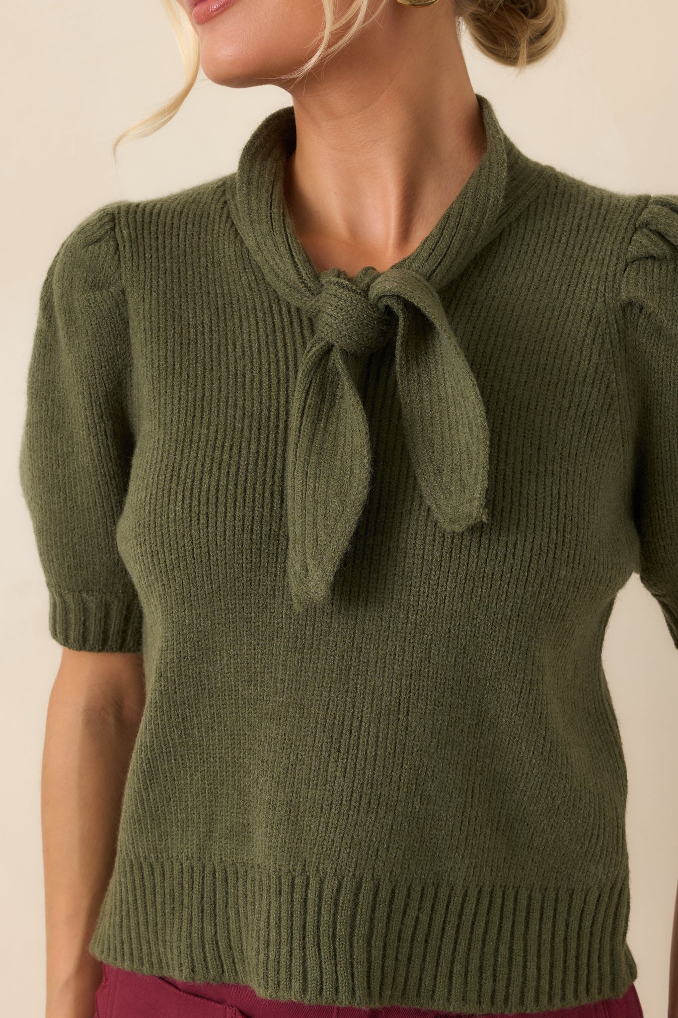 Close-up of the ribbed knit top highlighting the oversized bow detail, textured finish, and ribbed construction.