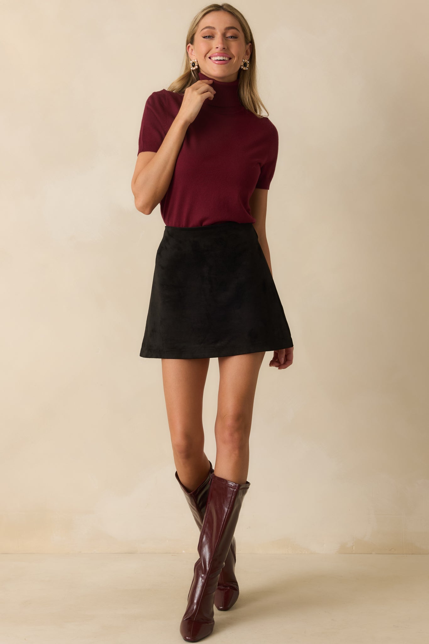 Ribbed knit wine red top featuring a rolled turtleneck and clean silhouette.