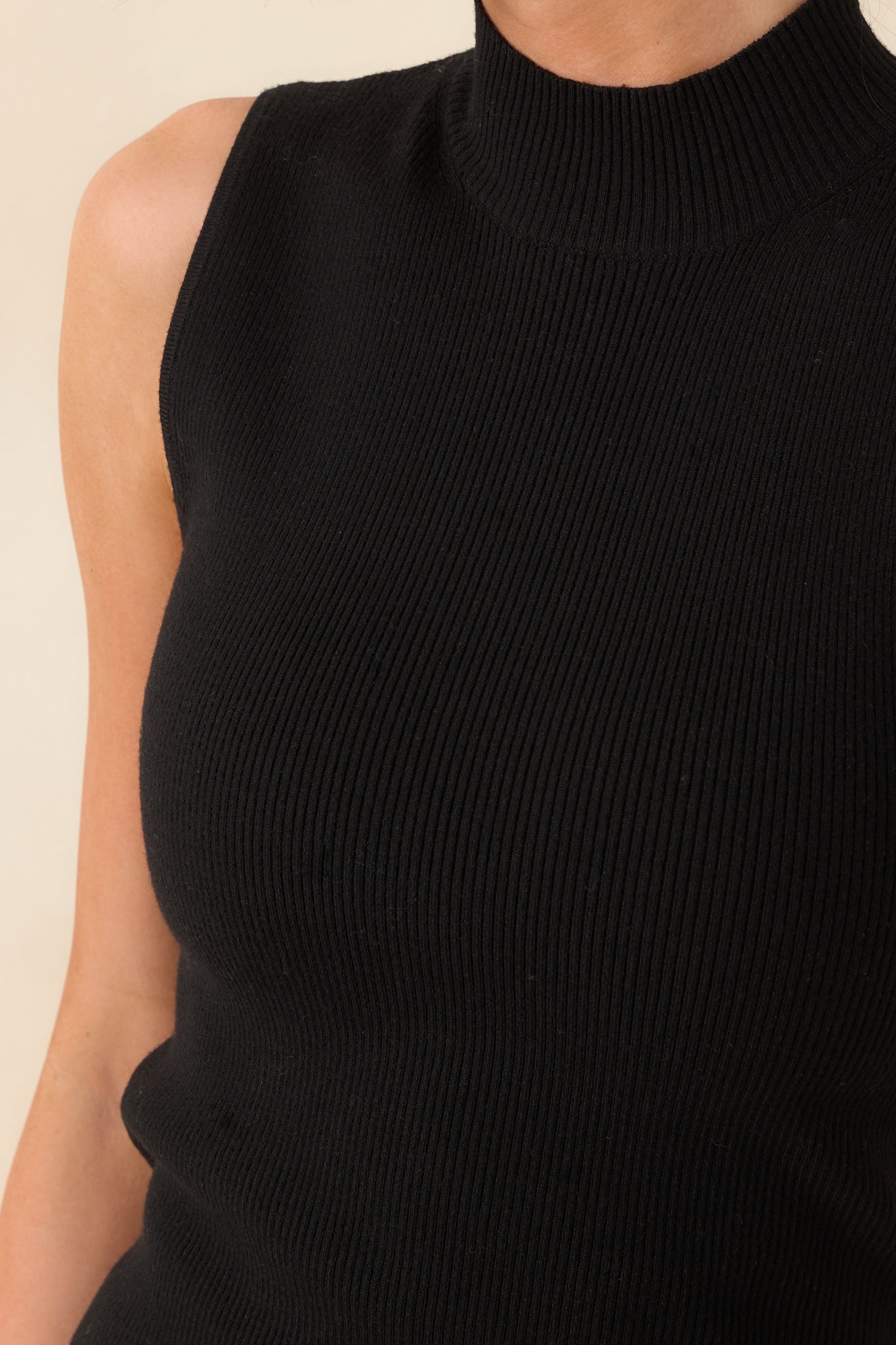 A close-up detail of the ribbed material and clean finish along the mock neckline.