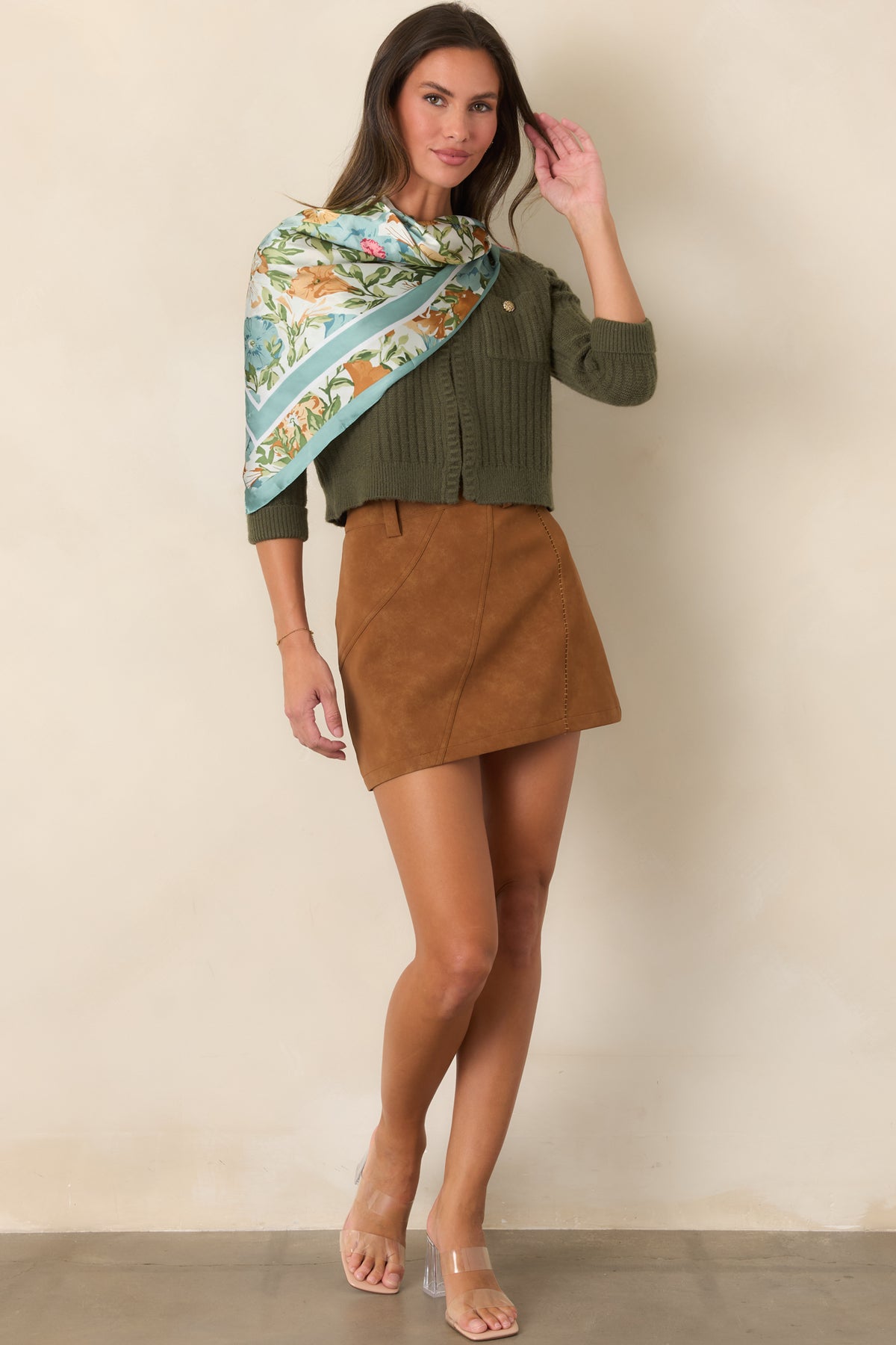 Ribbed moss green cardigan with a cropped silhouette and softly structured three-quarter sleeves.
