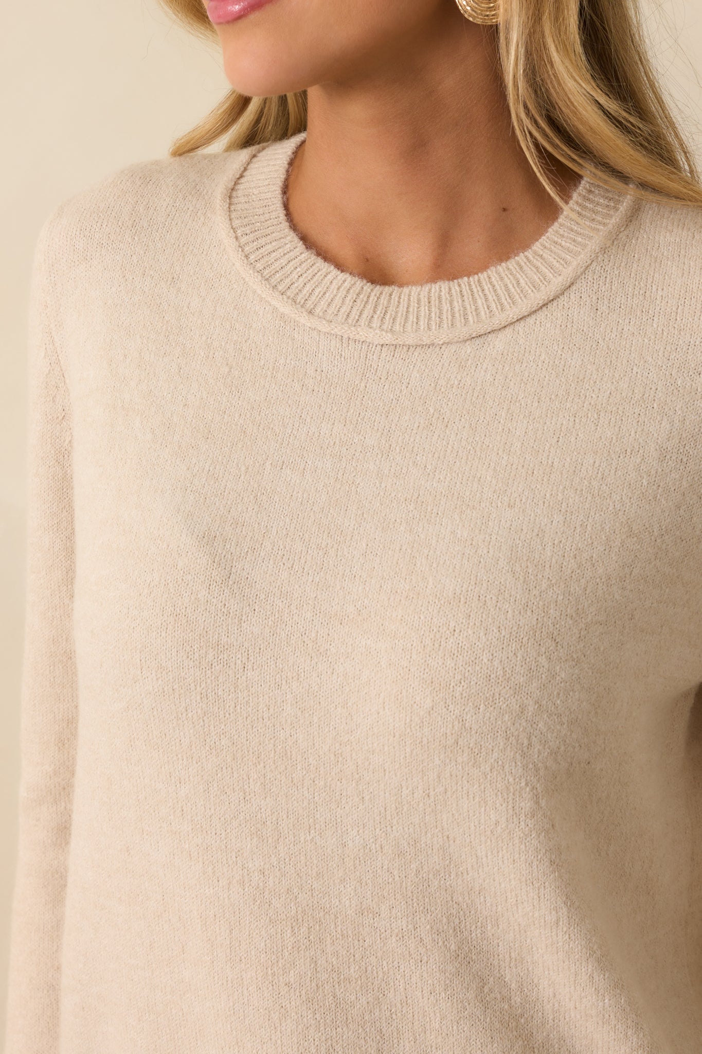 Close-up of the ribbed neckline, cuffs, and hem with textured knit on the oatmeal sweater.