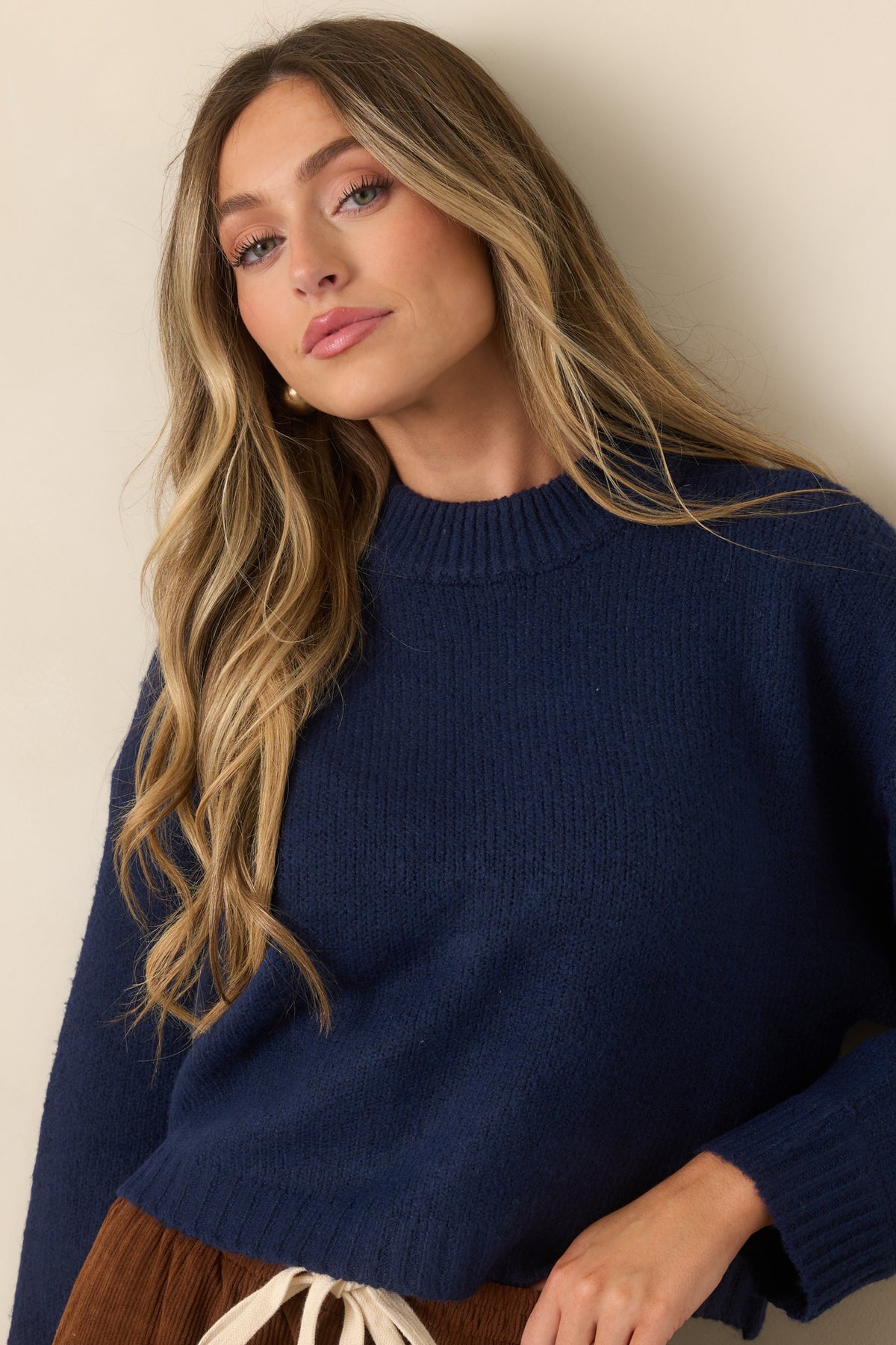 Ribbed trim frames the round neckline of this deep navy knit pullover with a relaxed silhouette.