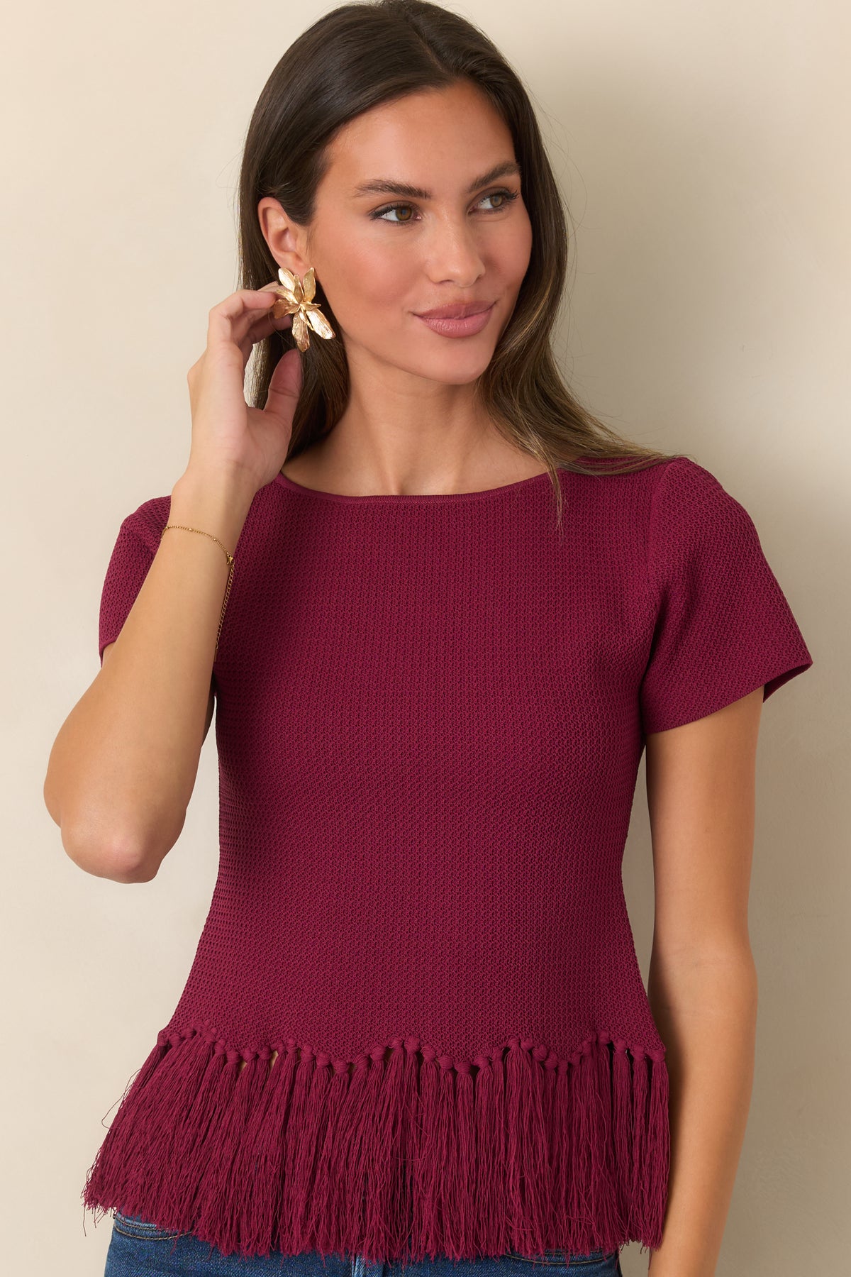 Rich berry top featuring a streamlined shape and playful fringe along the hem.