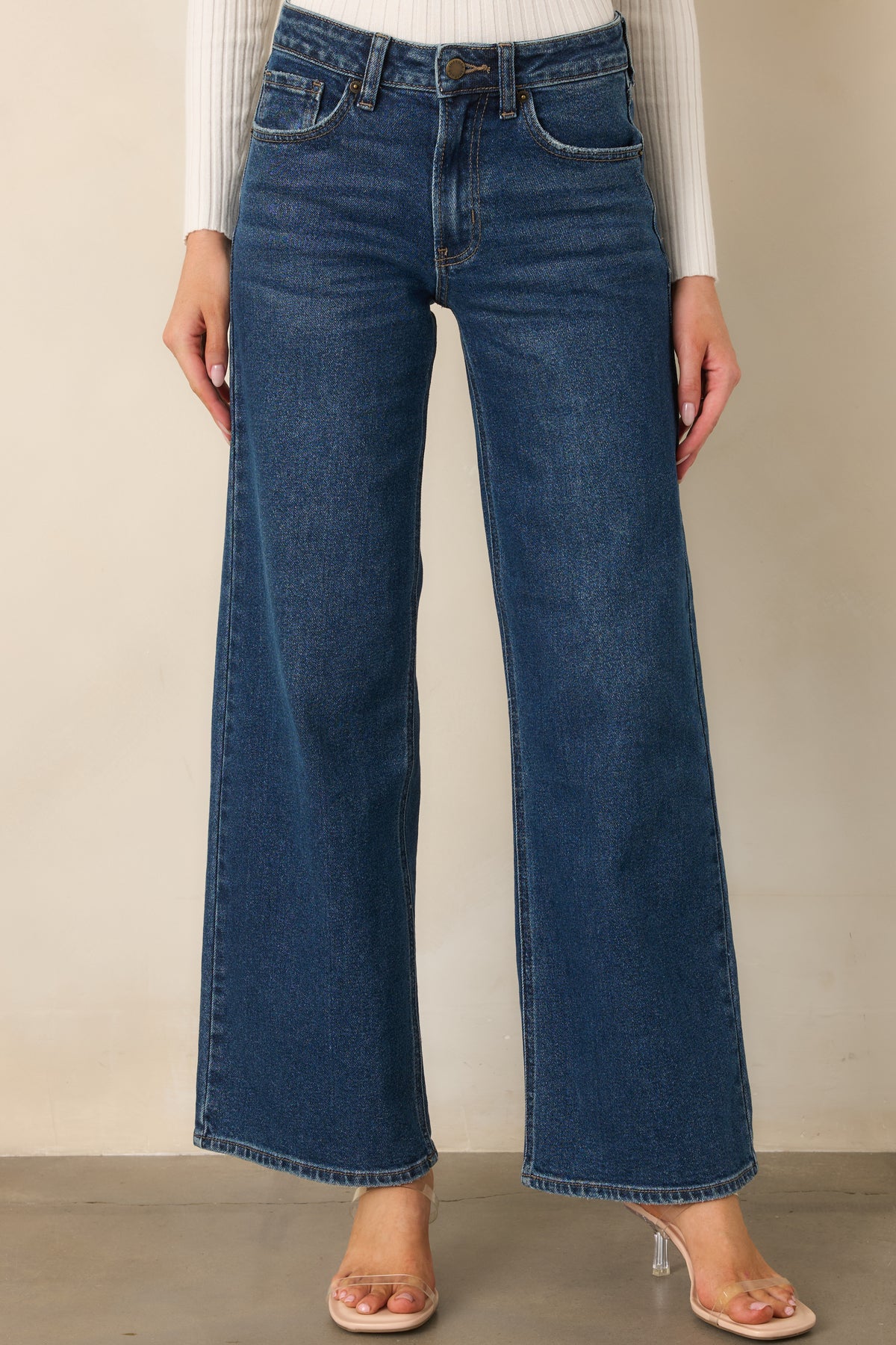 Rich blue jeans combine a defined high-rise waist with relaxed wide legs and neatly finished hems.