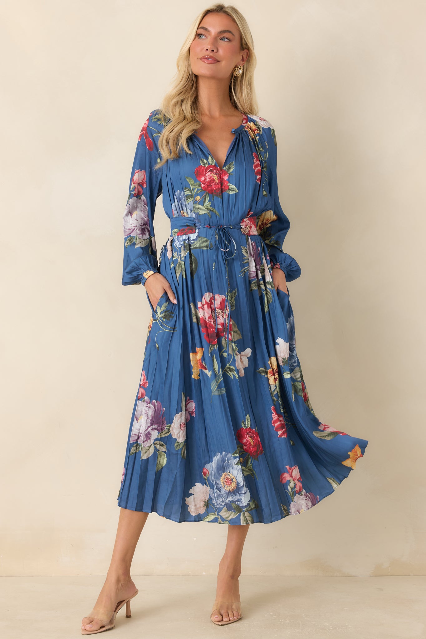 Rich blue midi dress showcasing oversized florals, elastic cuff sleeves, and elegant pleated texture throughout.