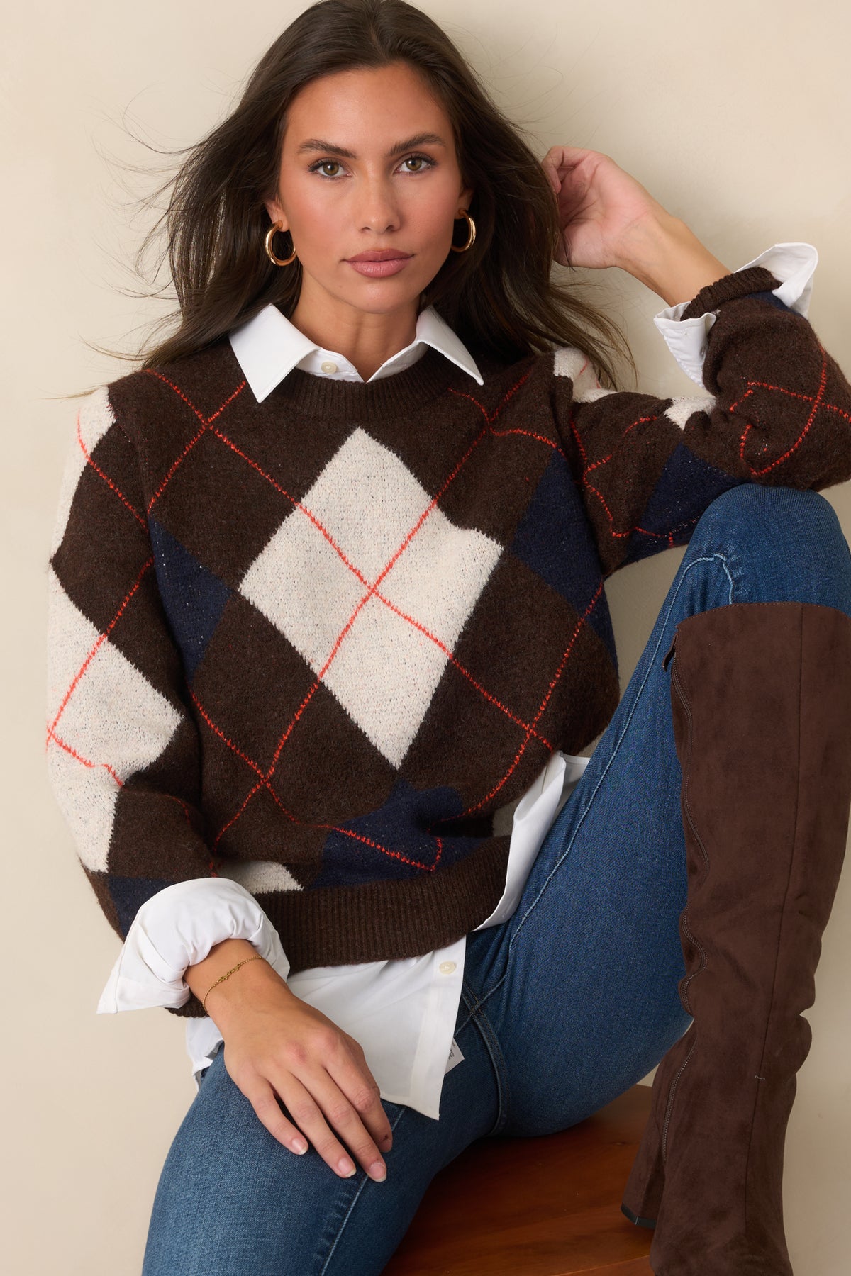 Rich brown knit top featuring an ivory and navy diamond pattern with fine rust-red lines, crew neckline, long sleeves, and ribbed trim.