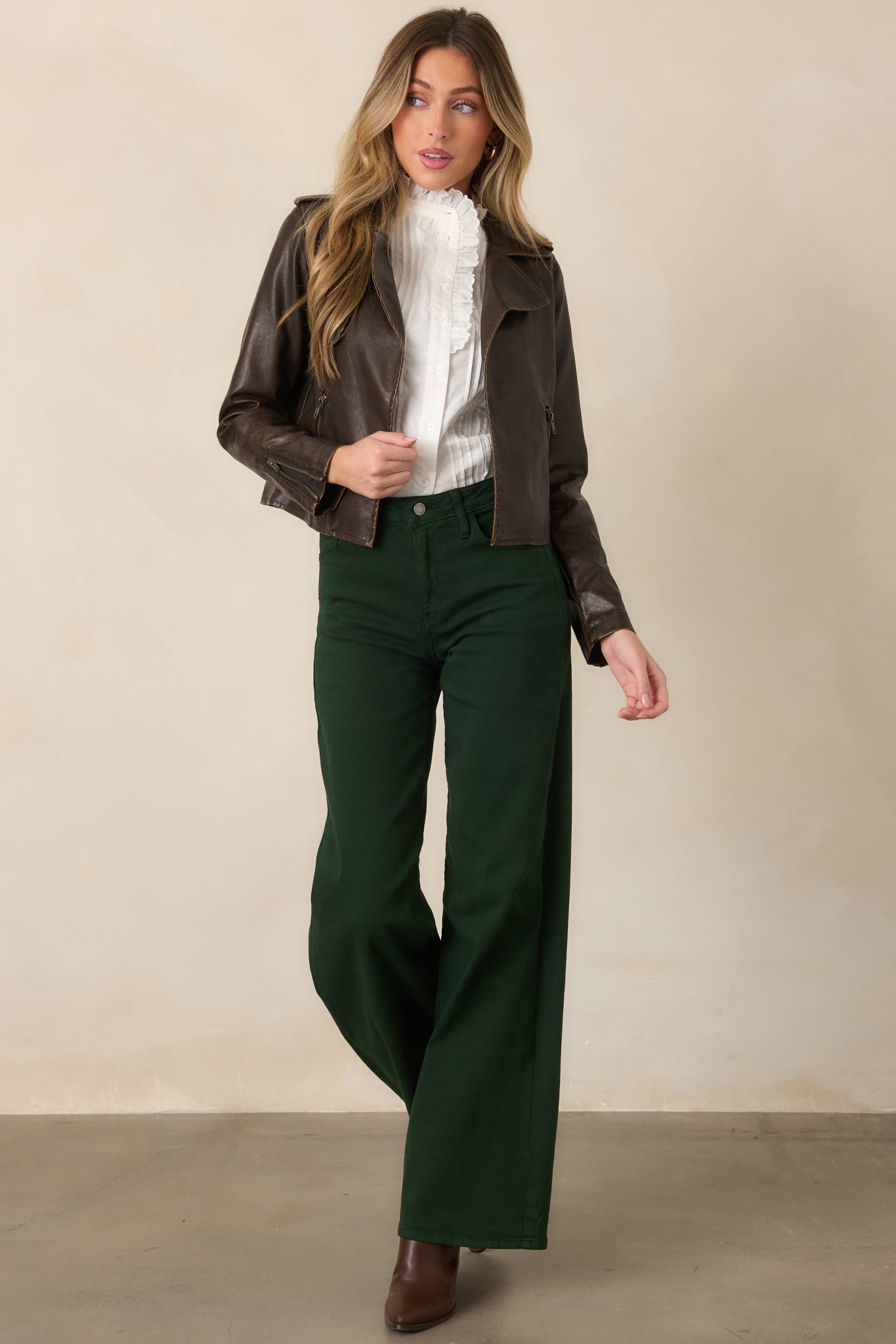 Rich brown faux leather jacket showcasing its wide lapels, sleek open front, long sleeves, and structured cropped fit.