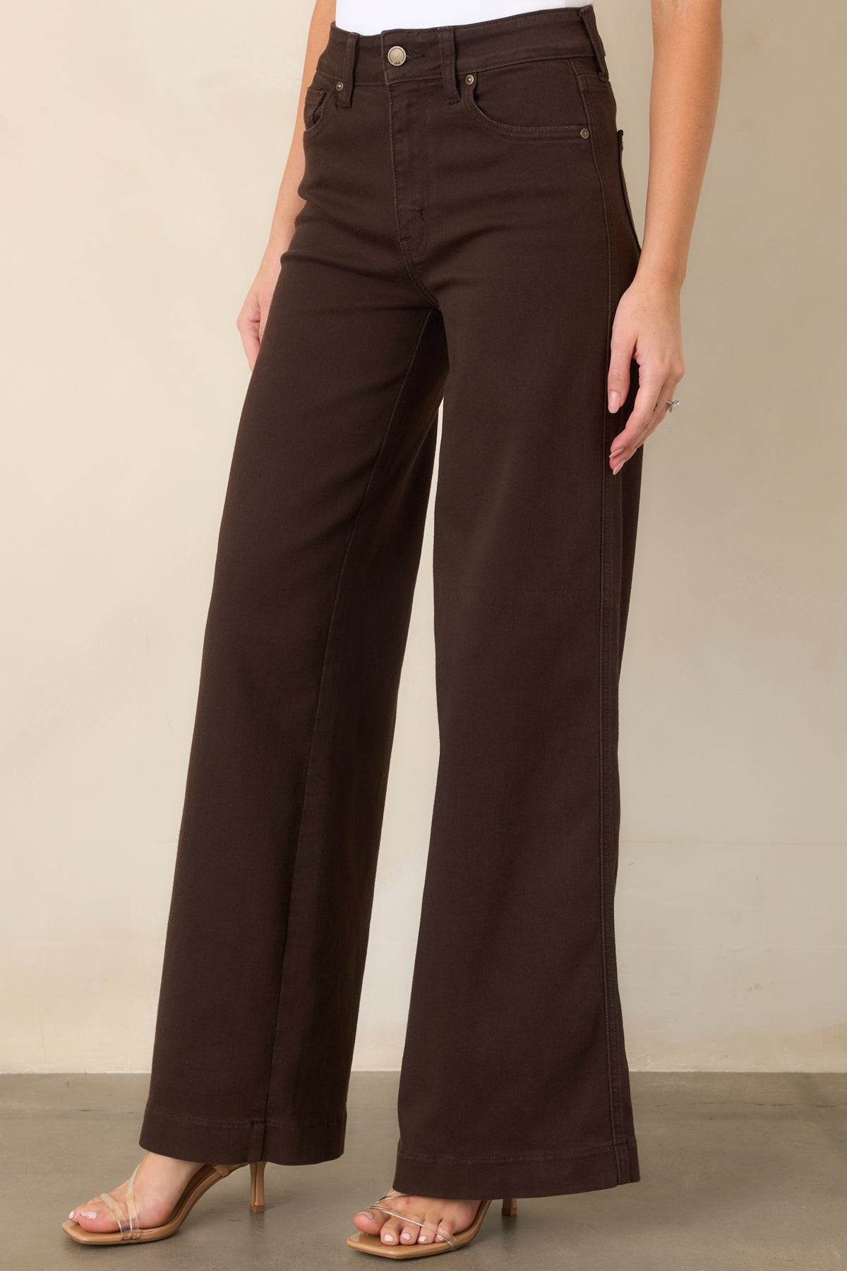 Rich brown jeans showcasing the classic five-pocket detailing, sturdy belt loops, and smooth denim texture.