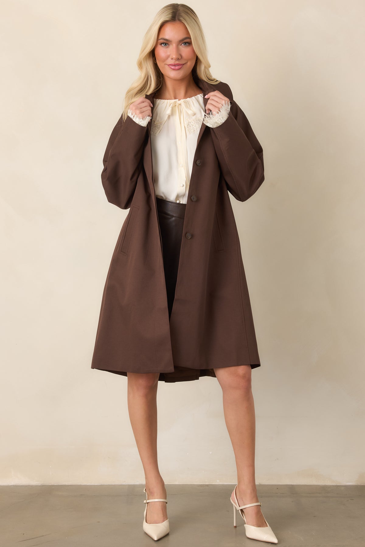 Rich brown coat featuring a relaxed silhouette, pointed collar, and side welt pockets.
