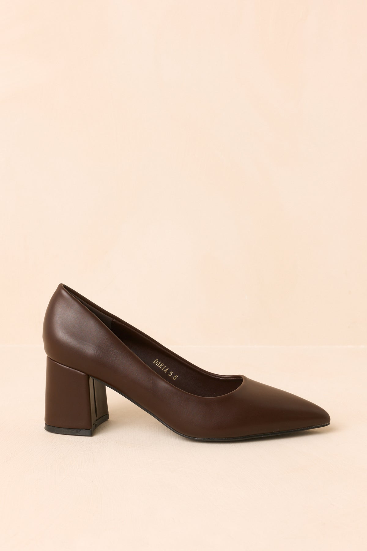 Rich brown heels highlighting the sleek upper and streamlined pointed-toe silhouette.