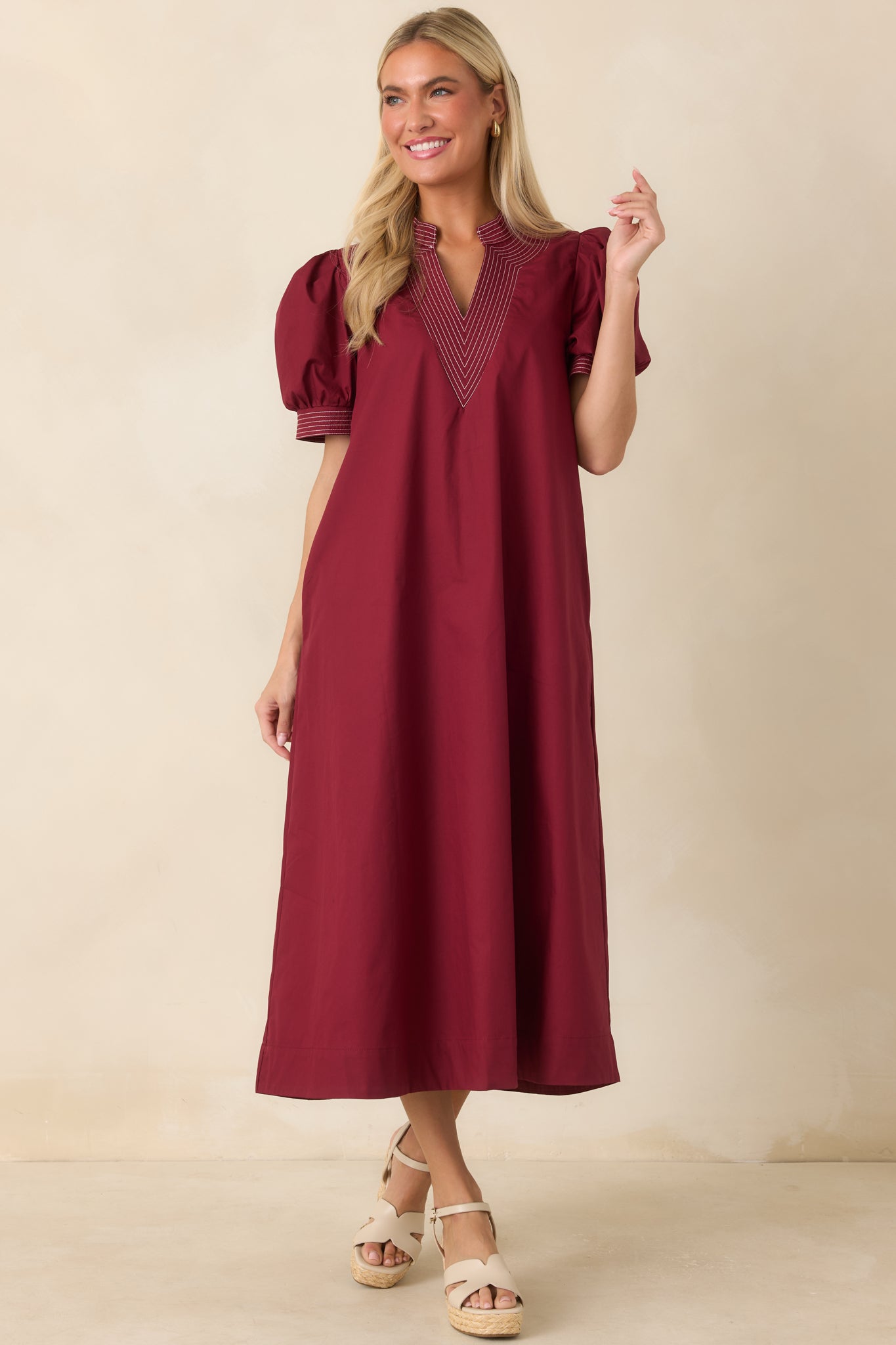 Rich burgundy A-line dress featuring short puff sleeves, defined stitching, and a polished finish.