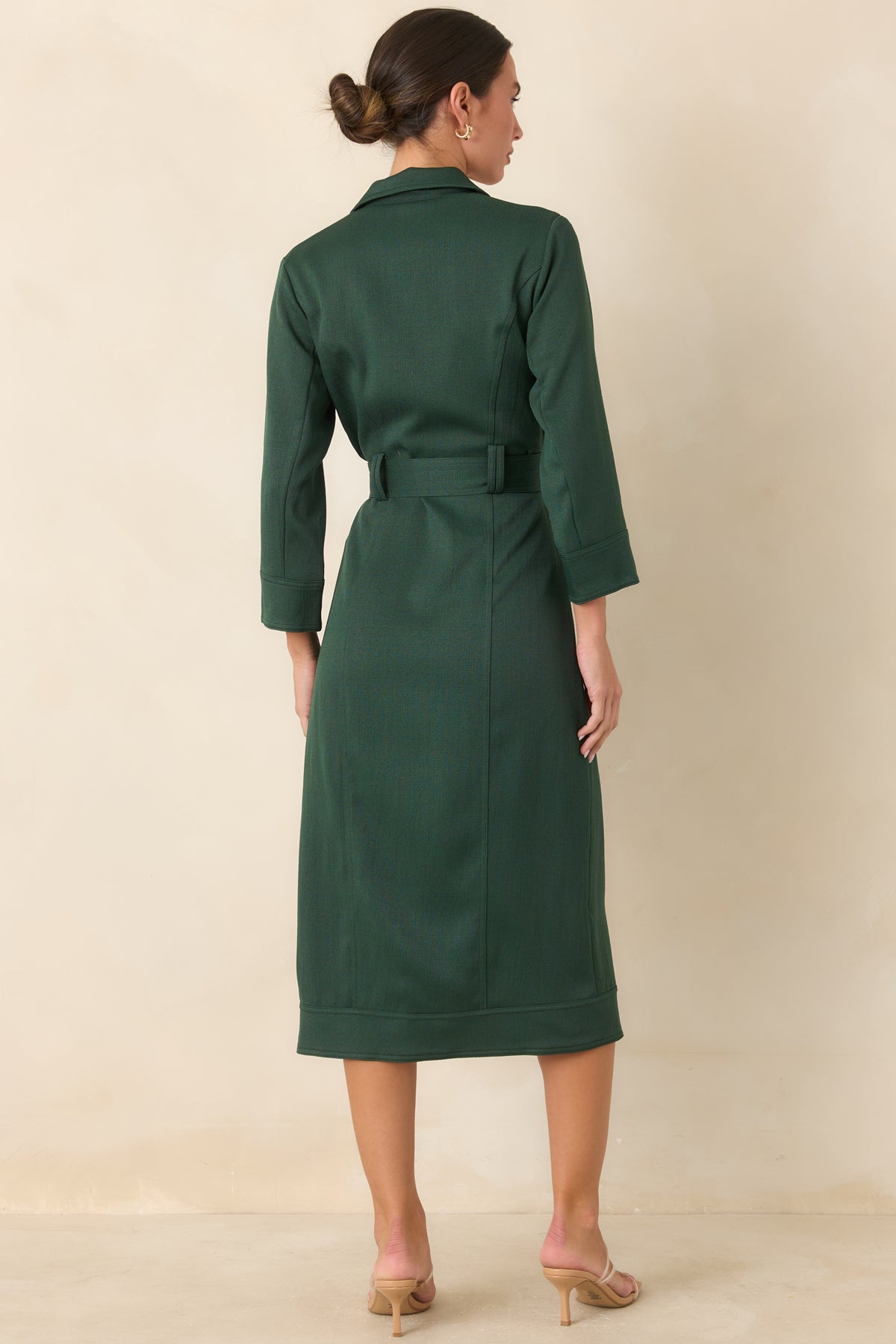 Rich green midi dress showcasing the tailored silhouette, bracelet-length sleeves, and straight skirt from the rear.