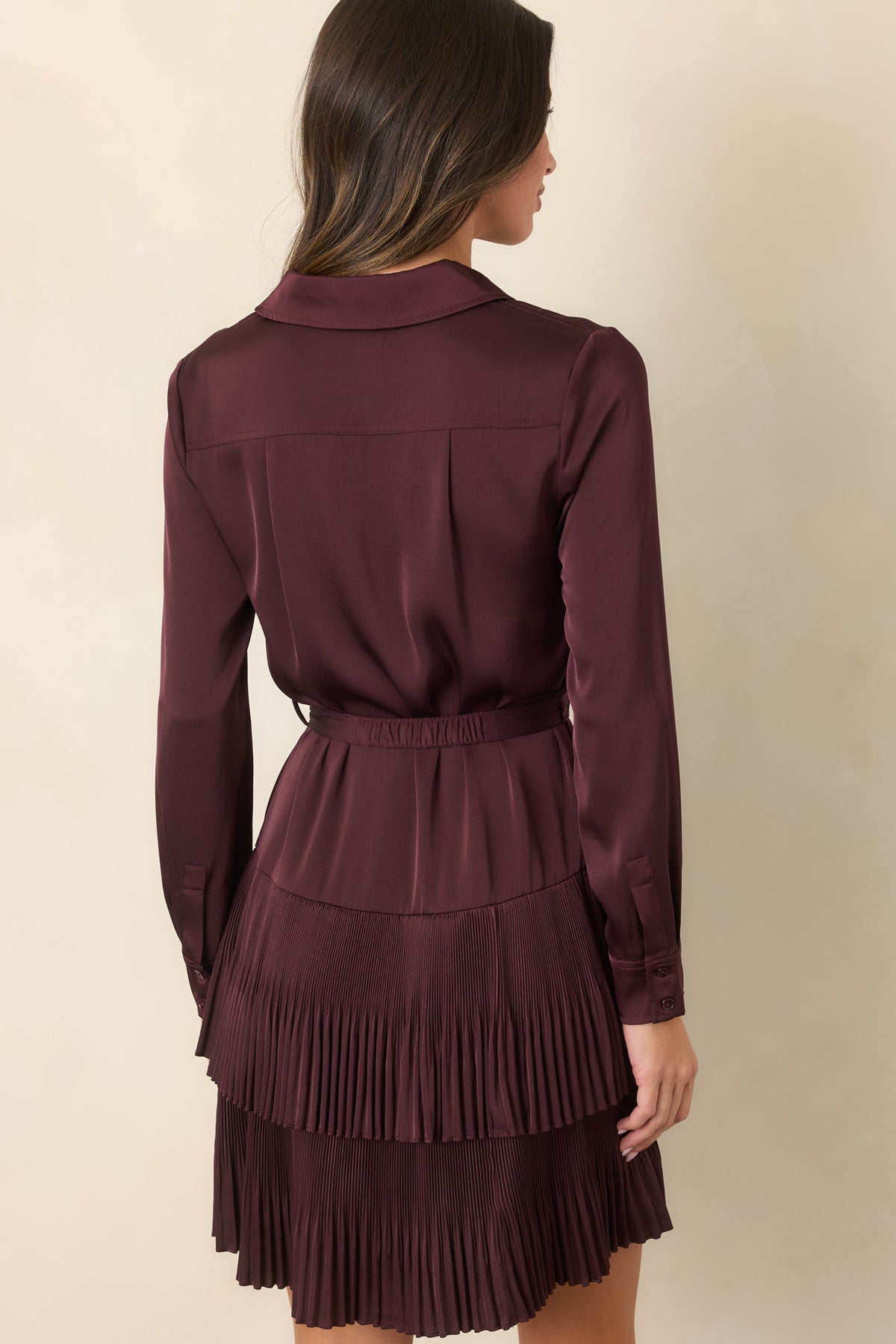  Rich plum mini dress showcasing the back yoke with a center pleat and long sleeves from the rear.