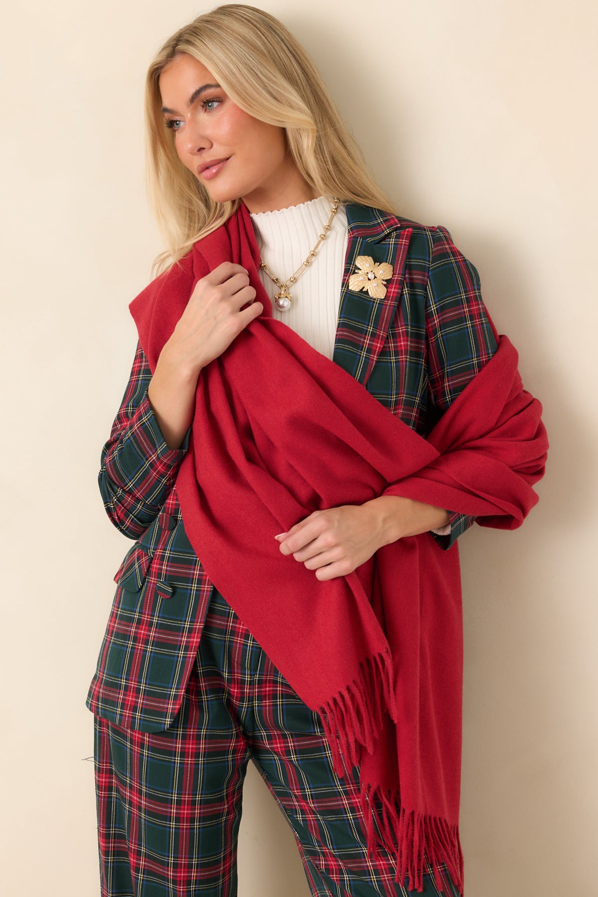 Rich red scarf draped in a generous silhouette with delicate fringe trim along the edges.