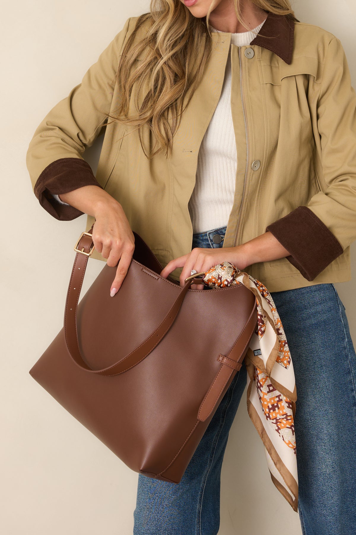 Roomy handbag with an adjustable shoulder strap and magnetic tab closure for everyday essentials.