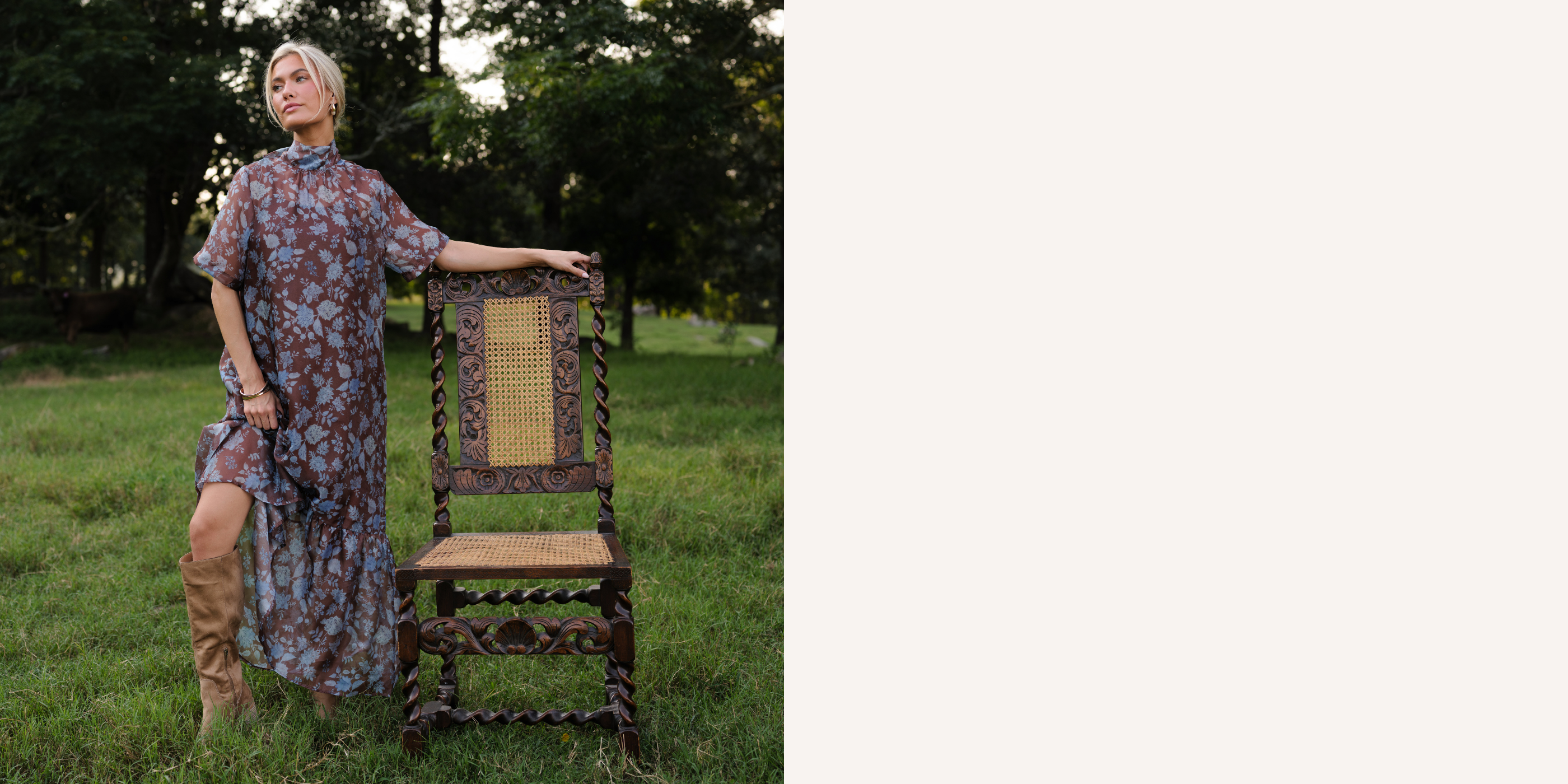 Women in a brown, sheer maxi dress with a blue floral print, brown slip underneath, and high neckline. She is standing in a field of tall grass with an antique wooden chair next to her. 