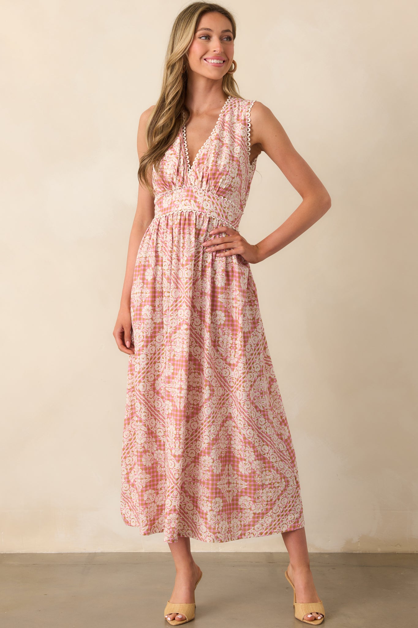 Full view of a rose pink dress with ivory floral print over a pink and tan gingham base, featuring a v-neckline and sleeveless design.