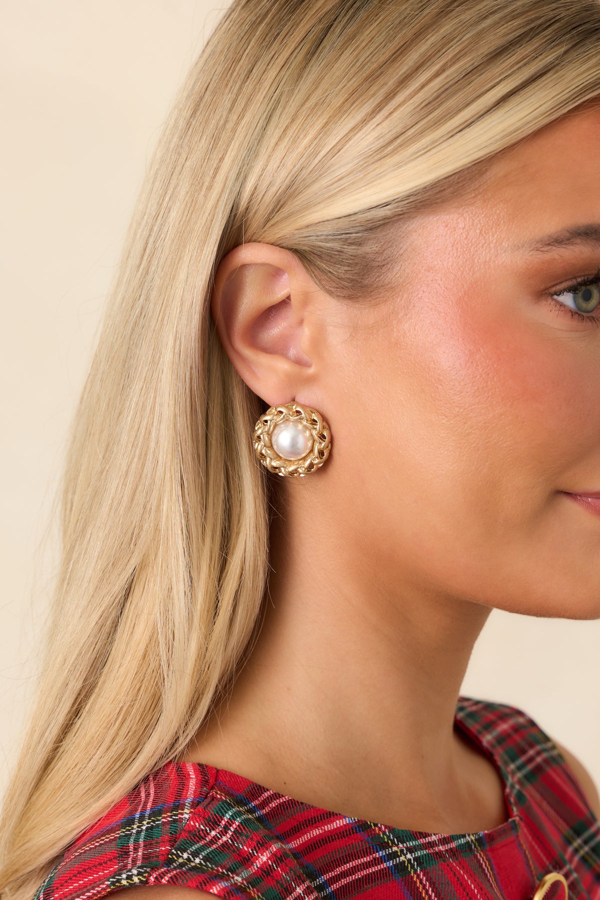 Rounded pearl earrings with dimensional gold-tone chain detailing woven around each luminous center.