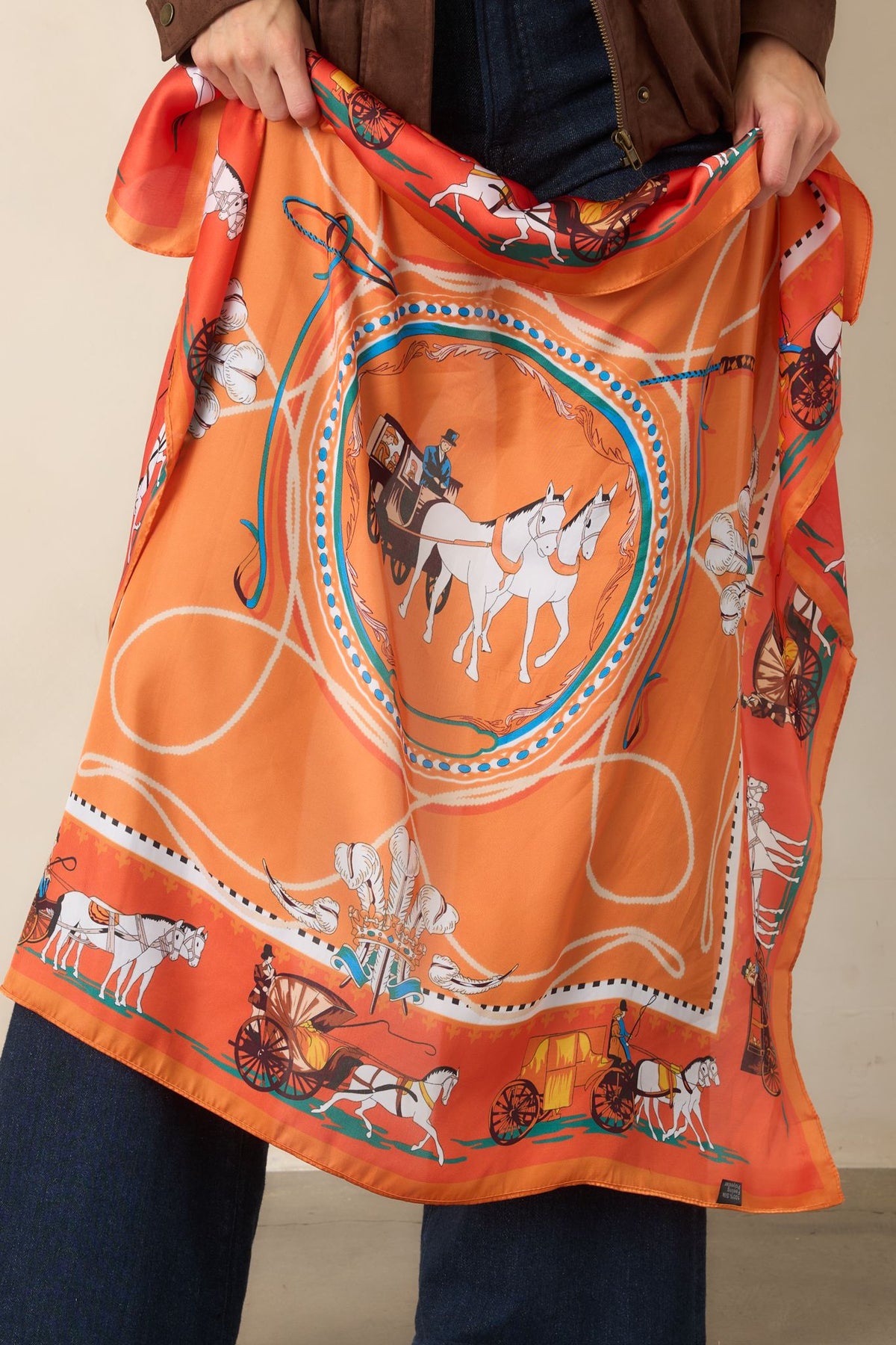 A Royal Journey scarf showcasing contrasting orange and teal coloring across its lightweight polyester fabric.