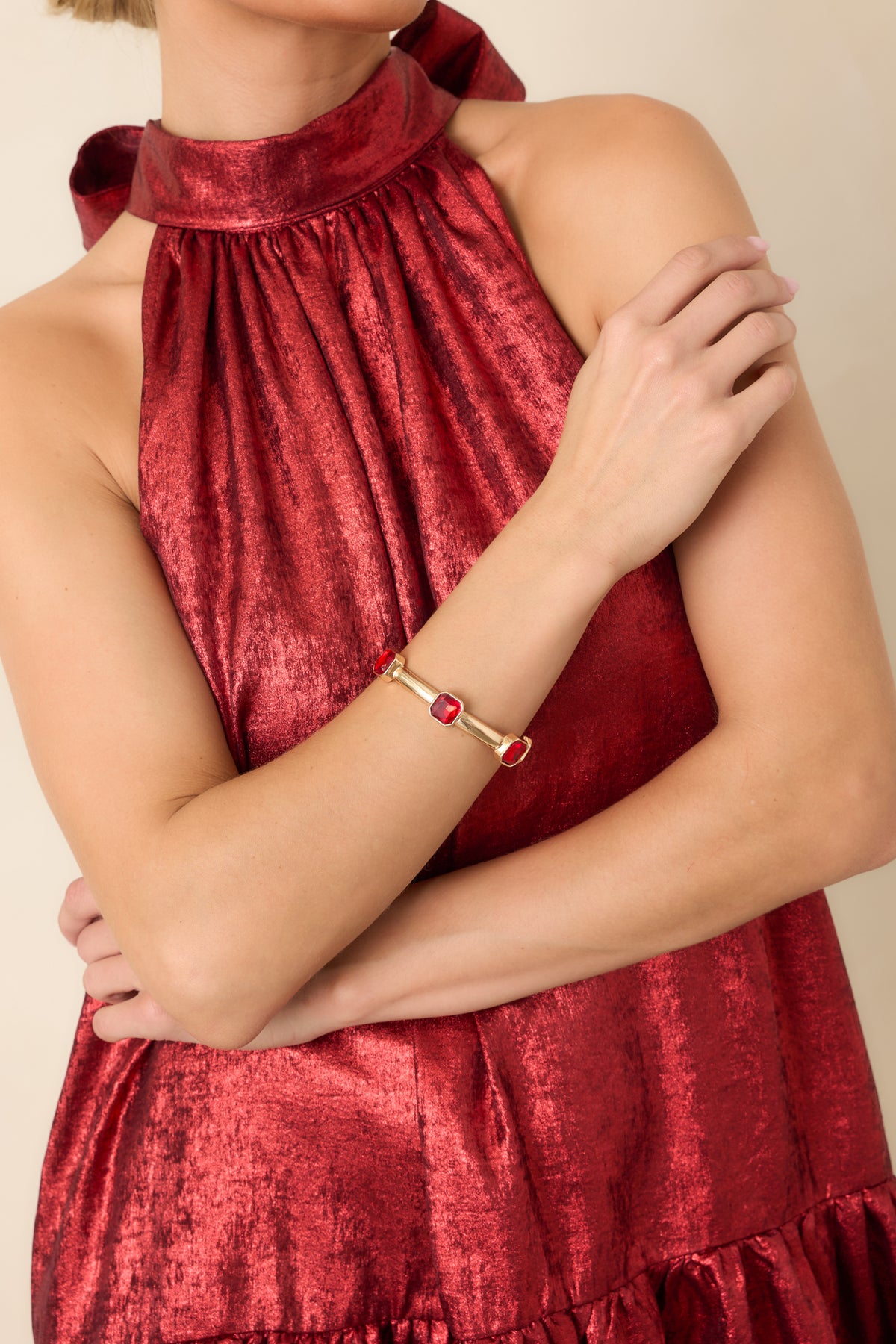Ruby red crystal bracelet with gold-tone frames and a smooth metallic band that highlights the rich red stones.