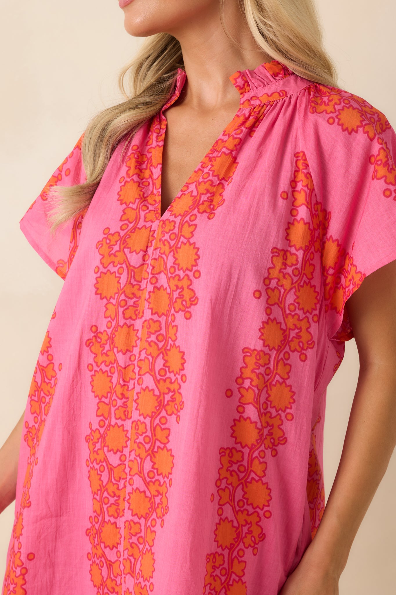 Close-up of the ruffle-trimmed collar, floral print, and lightweight dress fabric.