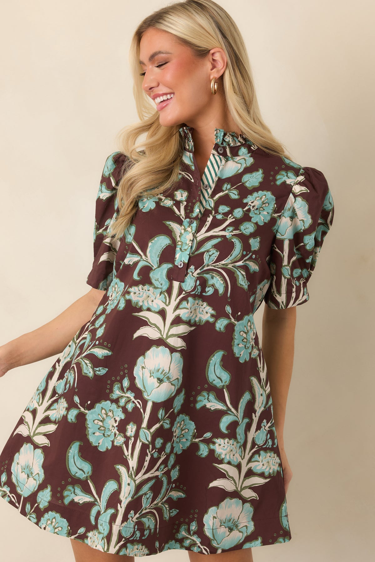 Ruffled stand collar frames the chocolate brown floral dress above its button-front placket and short puff sleeves.