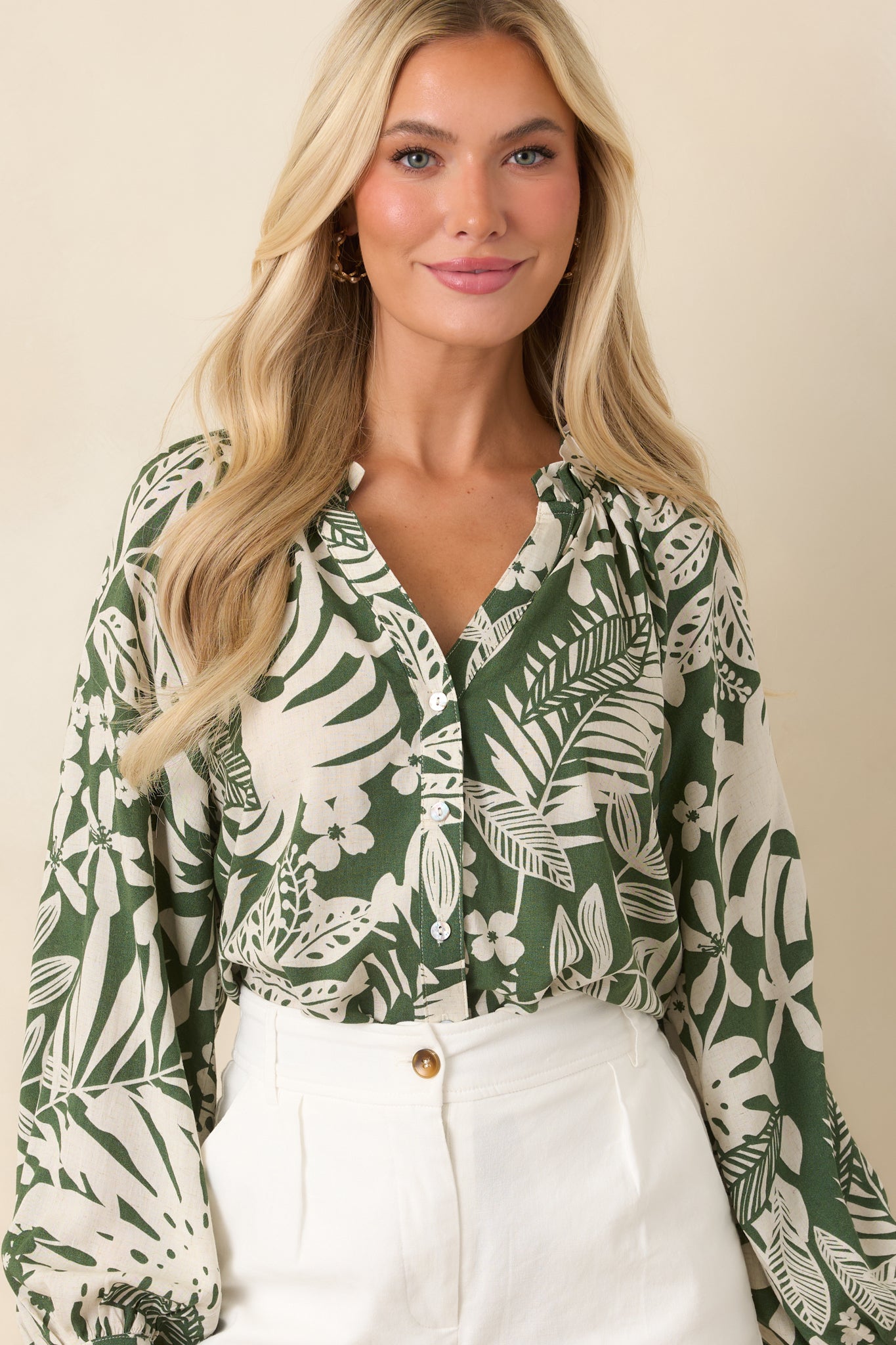 Close front crop highlighting the ruffled V-neckline and button-front placket on a lightweight fabric top.
