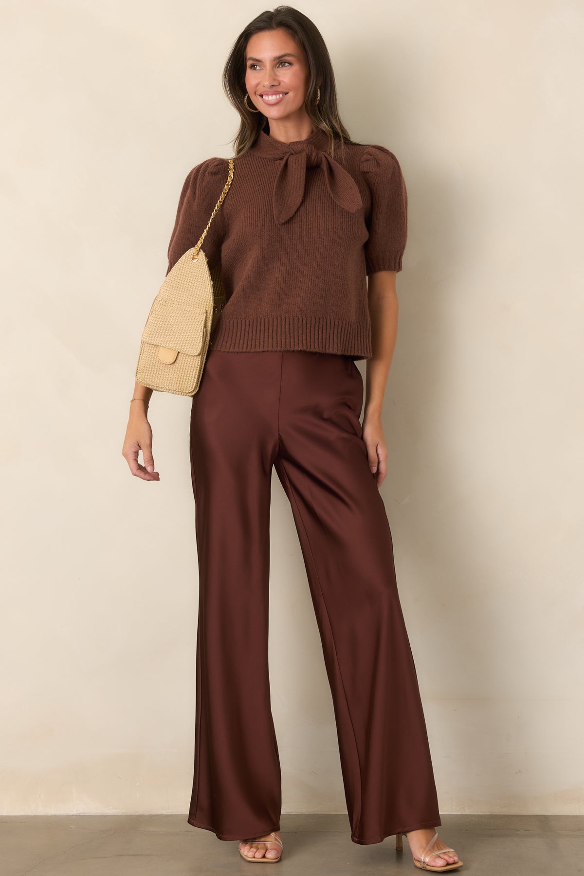Rust brown satin pants featuring a polished high-rise waist, flat-front waistband, fluid wide legs, and a subtle sheen.