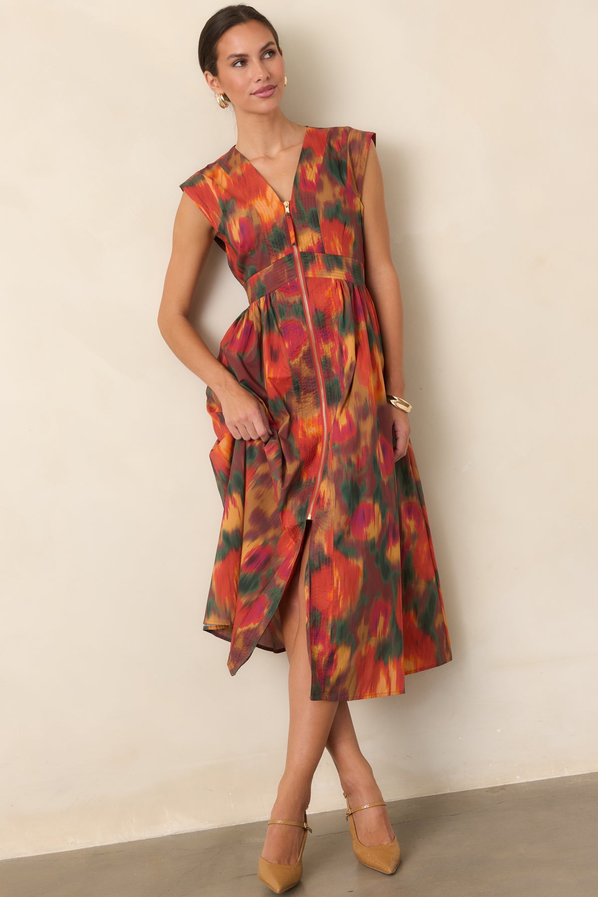 Rust floral cotton dress featuring a flattering V-neckline, sculpted cap sleeves, fitted waist, and voluminous midi-length skirt.