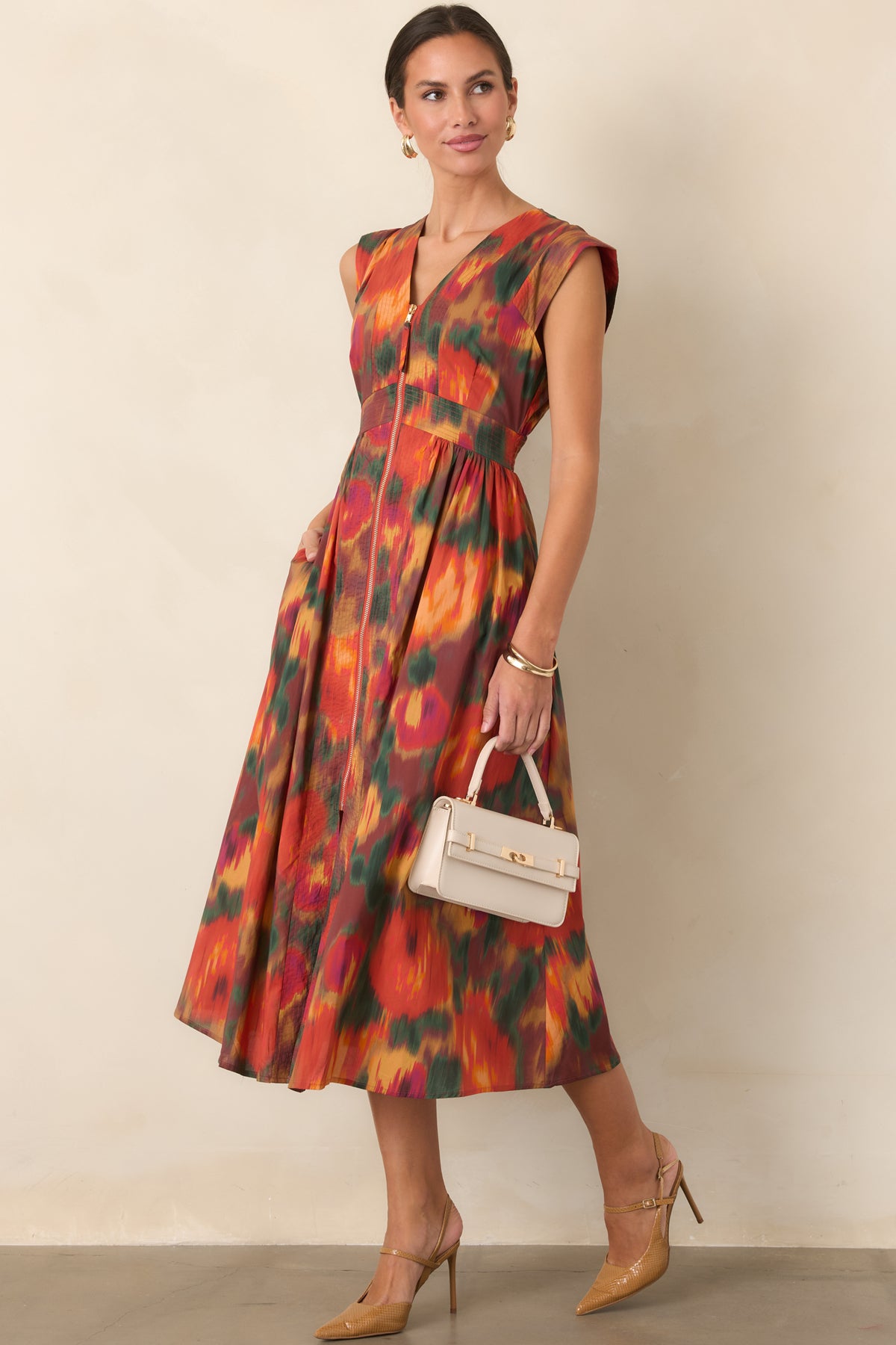 Rust multi floral dress showcasing orange, green, gold, and berry tones across a fitted bodice and flowing gathered midi skirt.