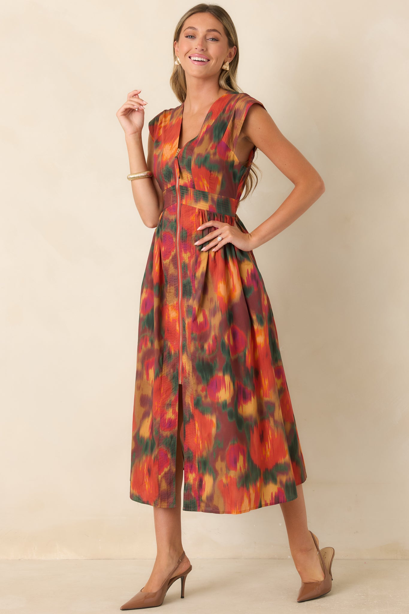 Full midi dress showcasing a vibrant rust floral print with colorful painterly accents, V-neckline, structured sleeves, defined waist, and softly gathered skirt.