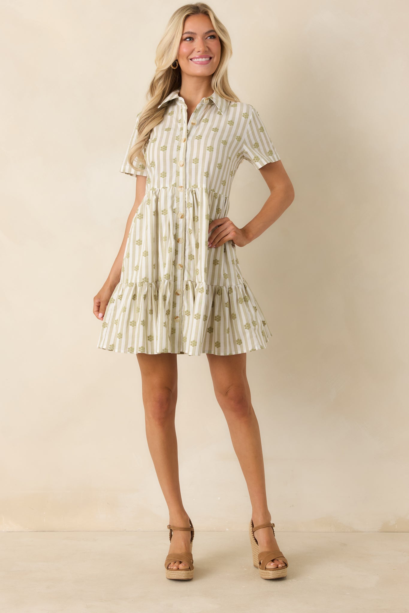 Sage green floral embroidered mini dress showcasing a relaxed cotton design with a classic collar, functional buttons, and practical side pockets.

