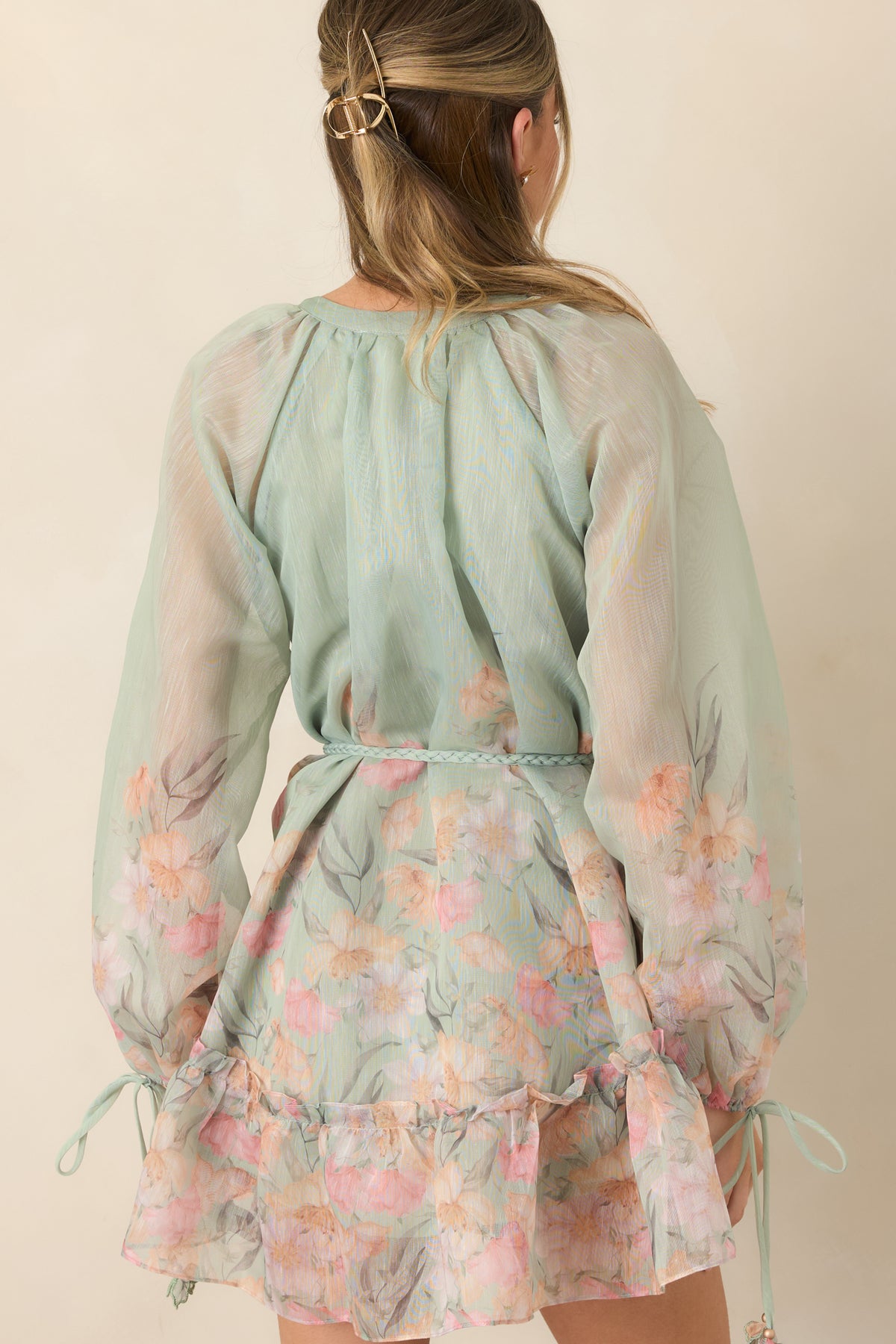 Rear of sage floral mini dress showing the billowy silhouette and tiered ruffle hem.