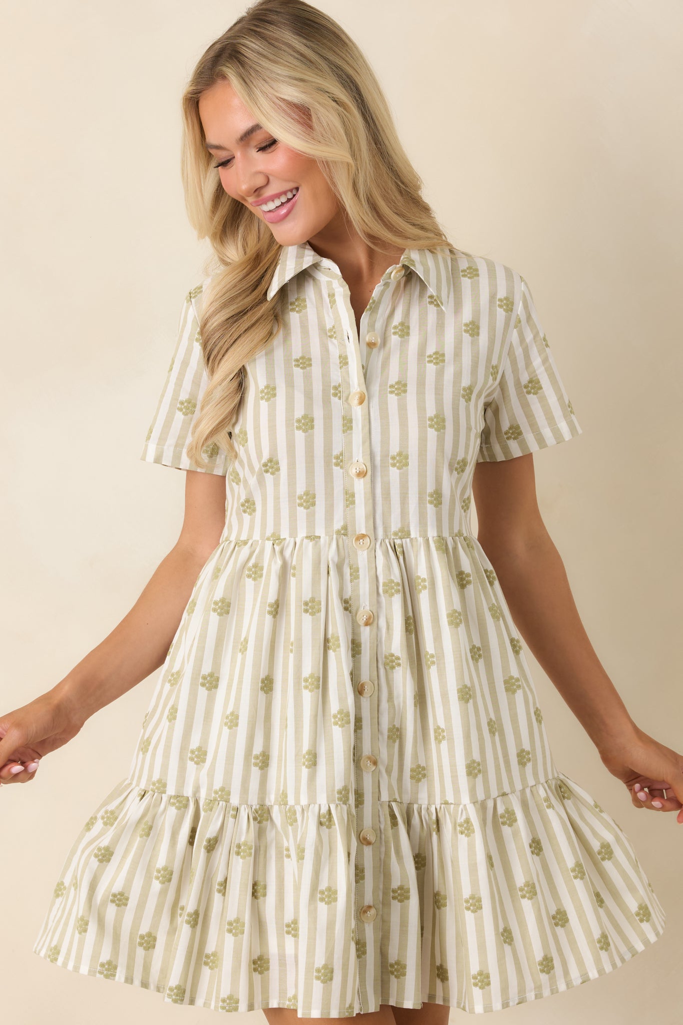 Detailed view of sage green cotton mini dress highlighting the floral stitching, collar design, and natural fabric texture.