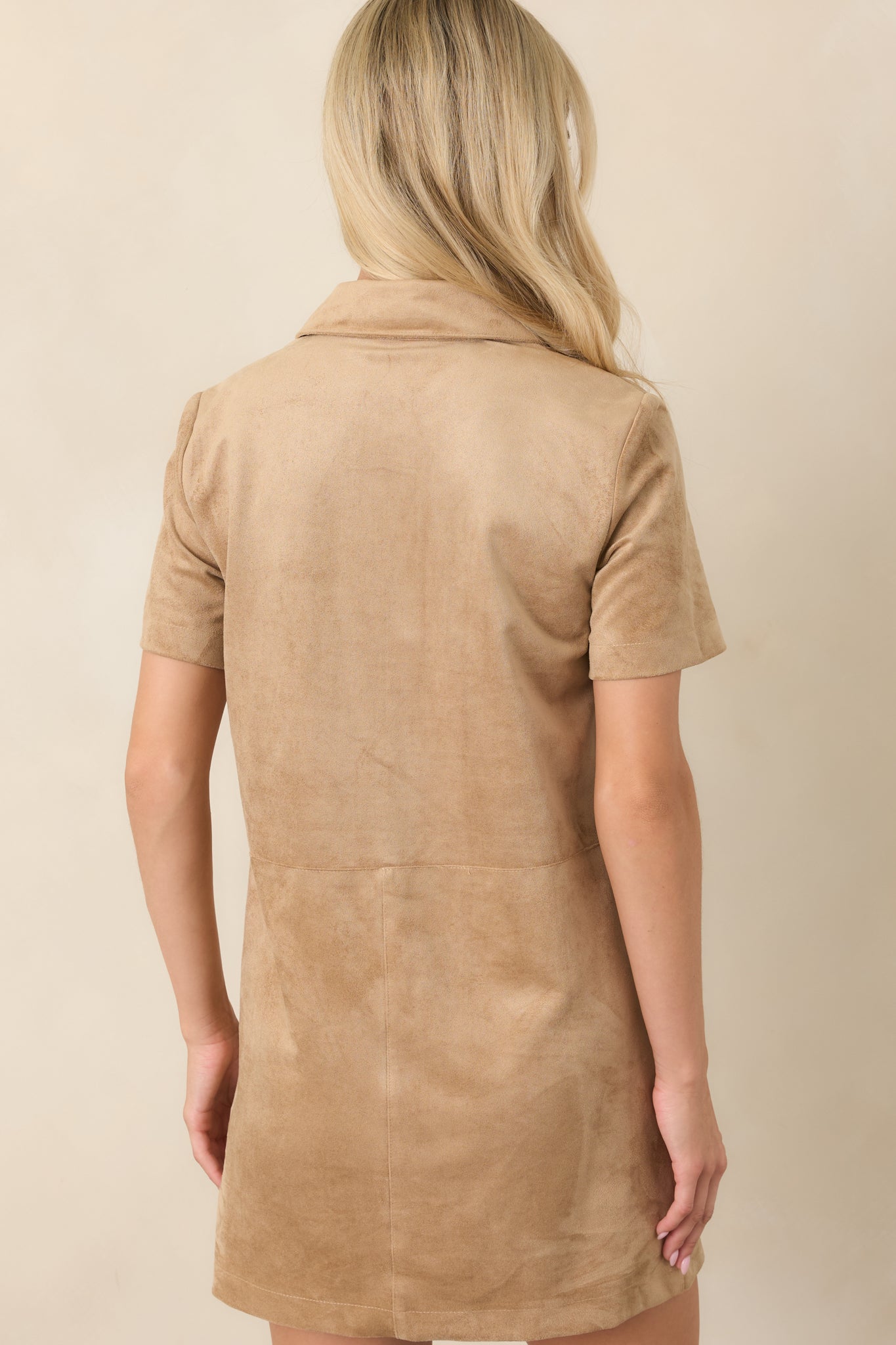 Rear view of the sand mini dress showcasing its straight silhouette and subtle seam detailing.