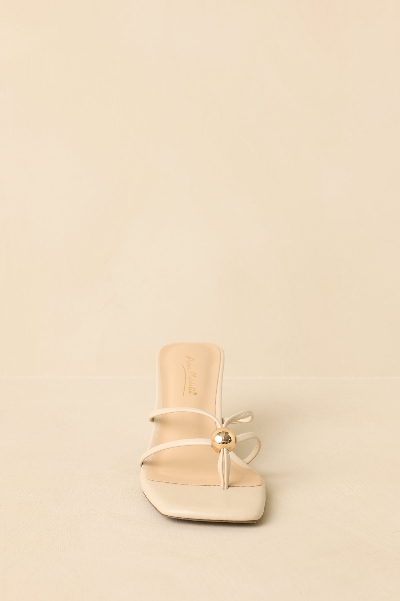 Kitten heel sandals shown from a low angle emphasizing the cushioned footbed and slip-on silhouette.