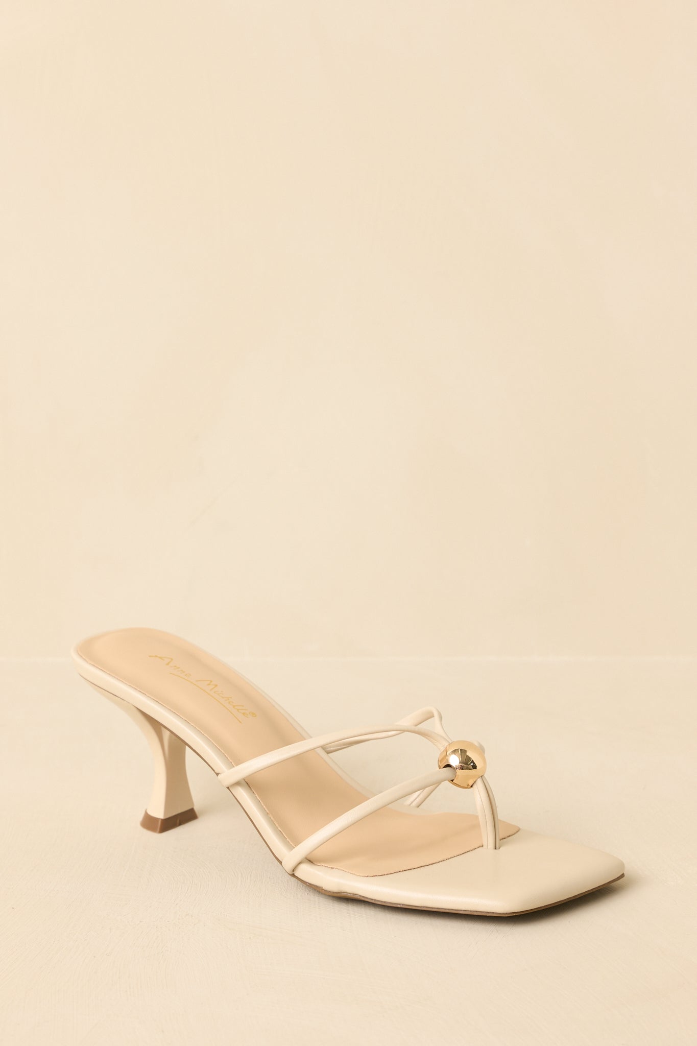 Sandals angled to highlight the toe and instep straps and gold bead detail.