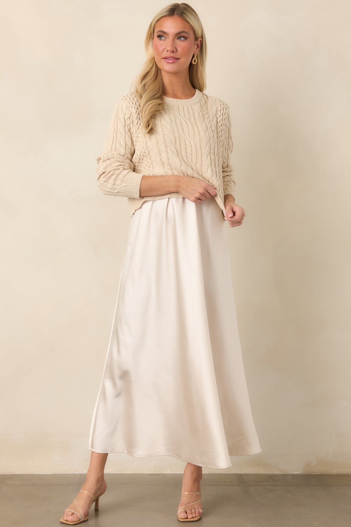 Satin A-line maxi dress featuring an elegant drape and richly textured mixed cable-knit sweater.