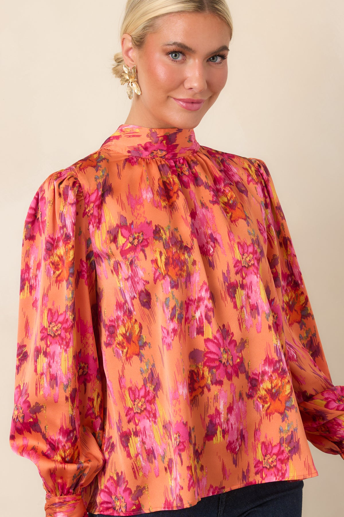 Satin blouse detail featuring a long balloon sleeve finished with a buttoned cuff and softly gathered fabric at the shoulder.