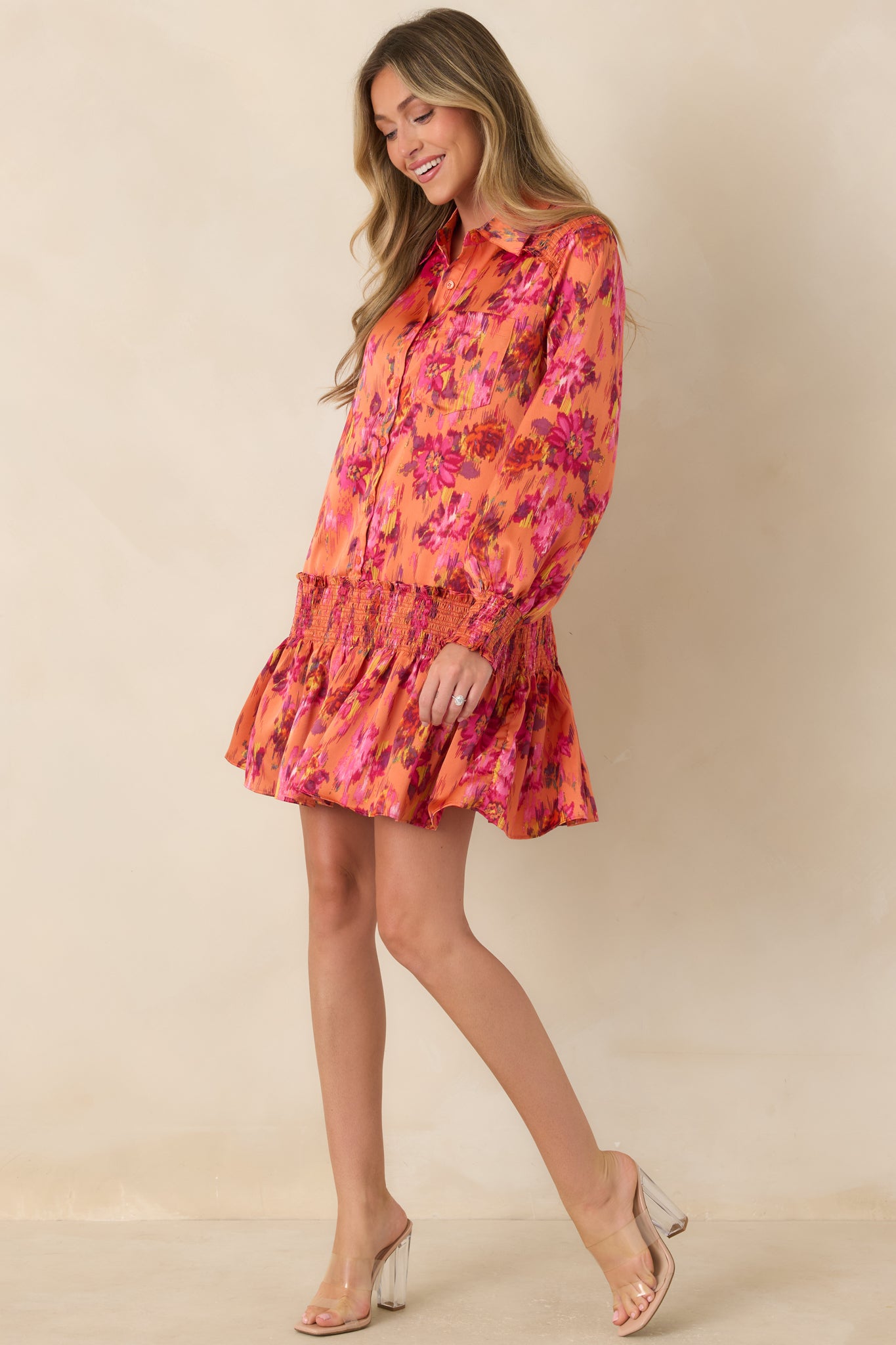 Polyester satin mini dress featuring a collared button-front design, long balloon sleeves, smocked cuffs, a drop waist, and flouncy skirt.