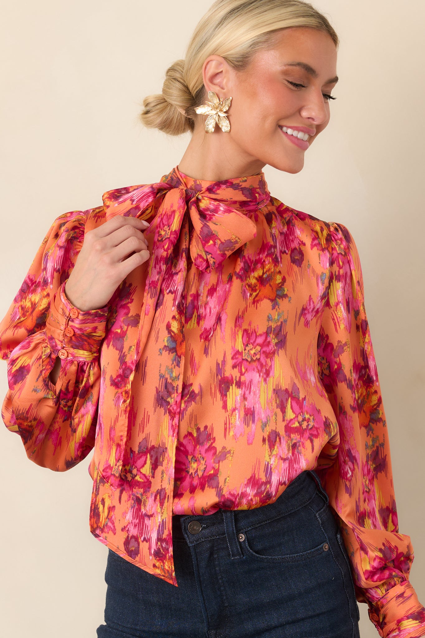 Close view of the satin top highlighting the dramatic tie neckline, softly gathered shoulders, and smooth lustrous fabric.