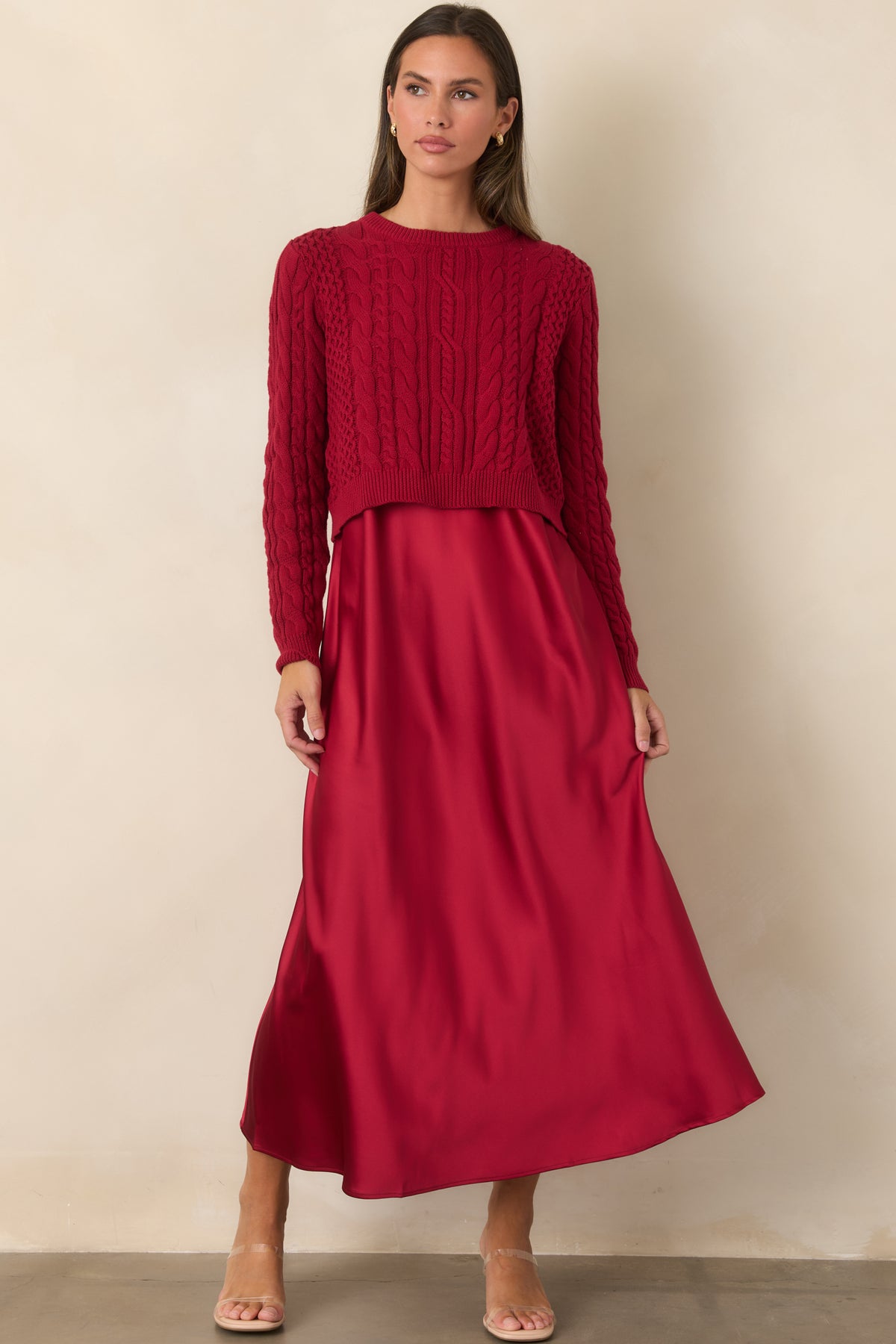 Satin maxi dress layered with a cropped cotton sweater featuring mixed cable-knit detailing.
