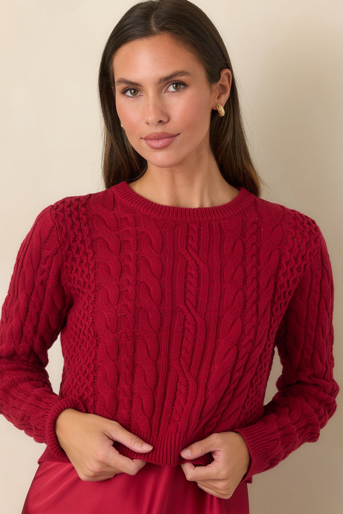 Satin maxi dress detail showing the fluid drape paired with the cropped cable-knit sweater.